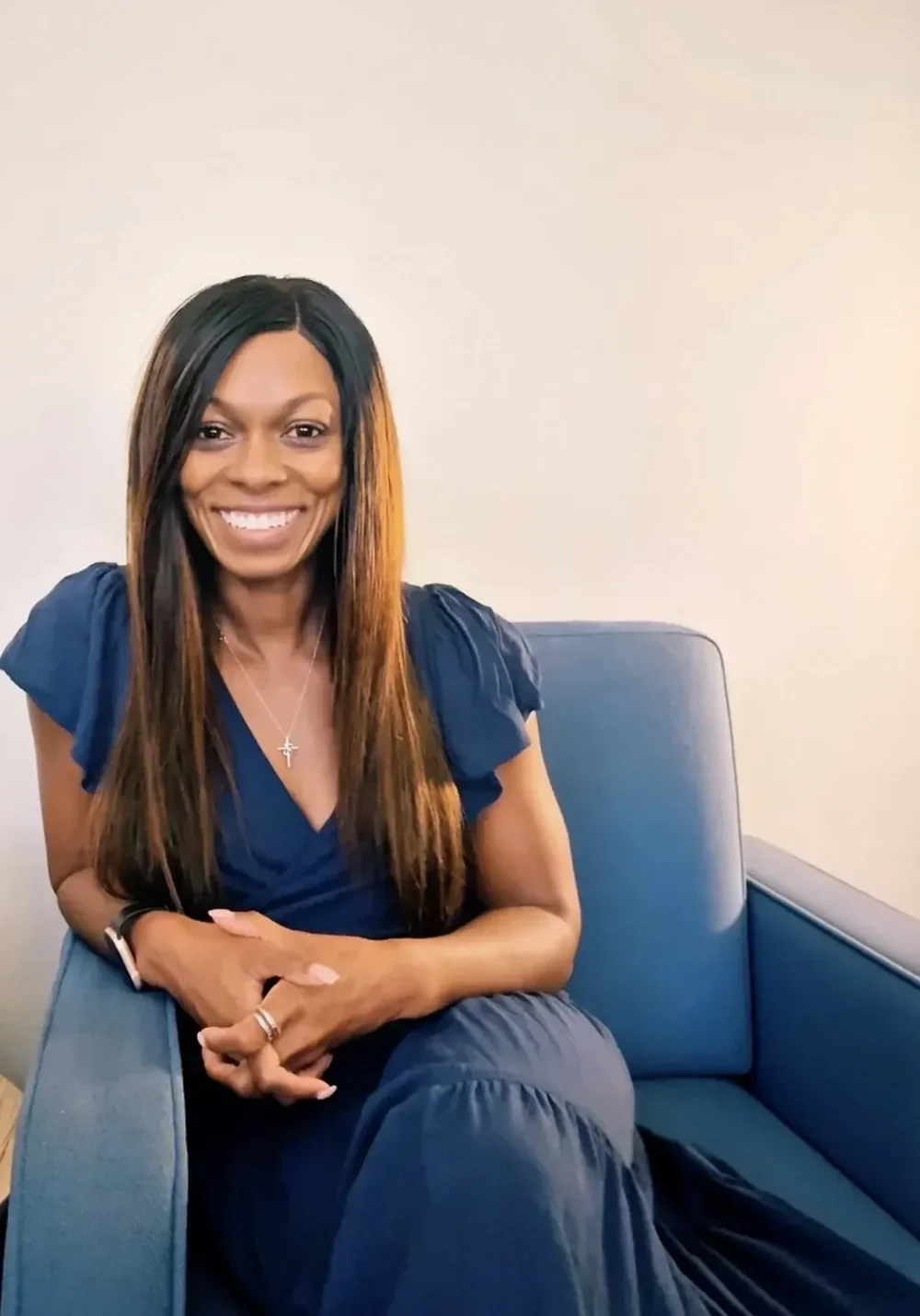 Dr. Quinnett Swank, Las Vegas therapist, seated in a blue chair wearing a navy dress