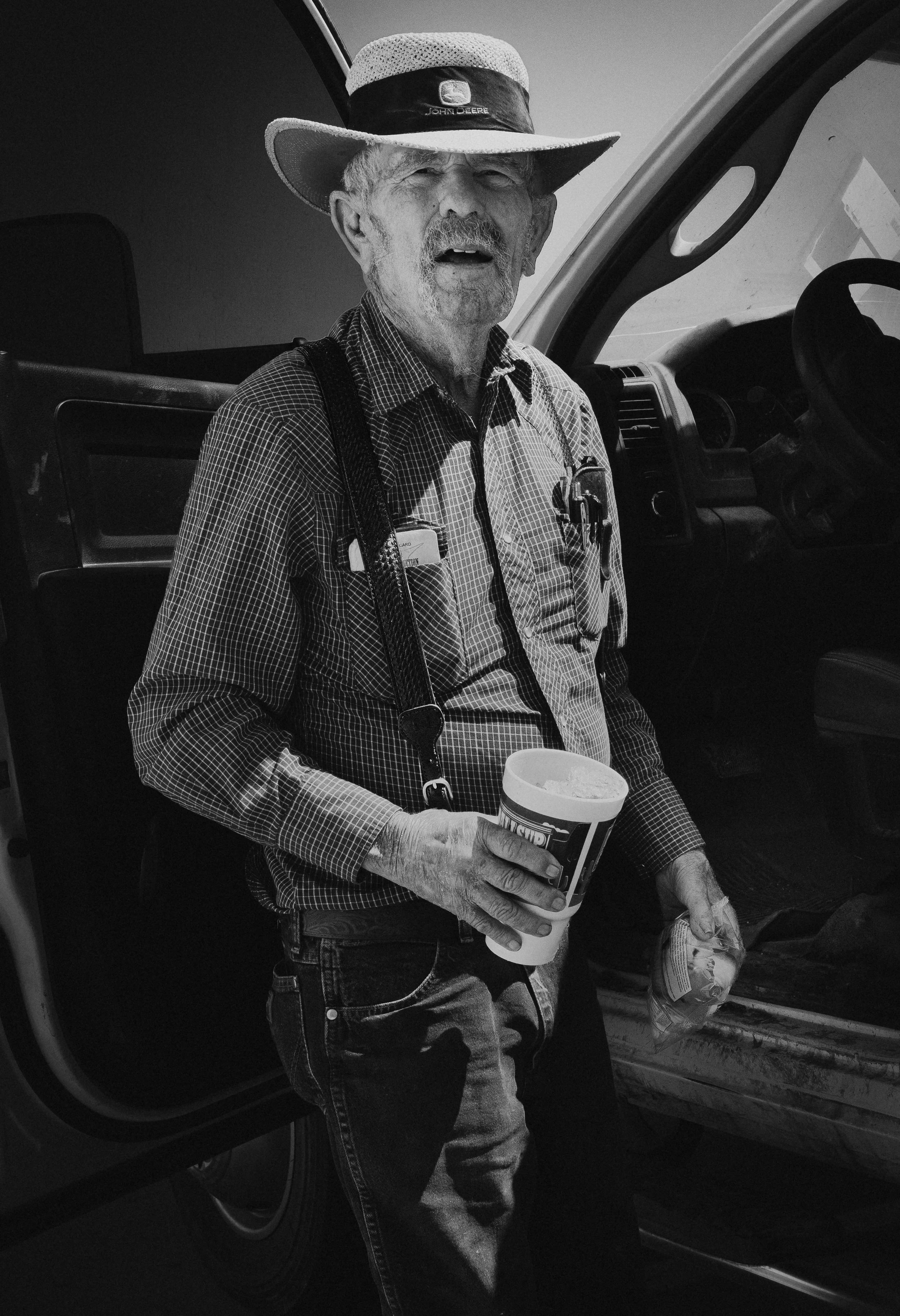 A farmer gets a midday refreshment at a gas stations in Friona, Texas. I asked him if I could take his picture and he said "That's fine." and held this exact pose for about 10 seconds before turning around and getting into his truck.