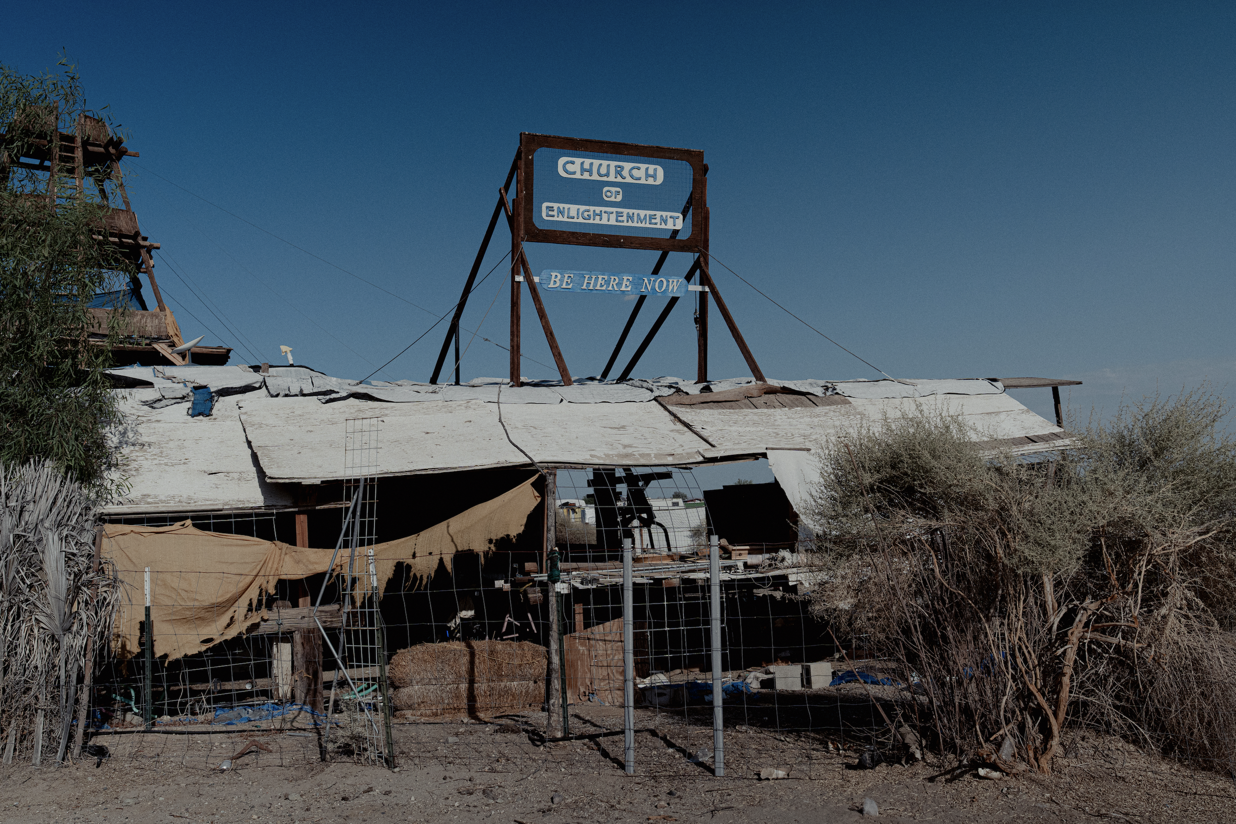 'Be here now' posted over the abandoned, trash filled church. 