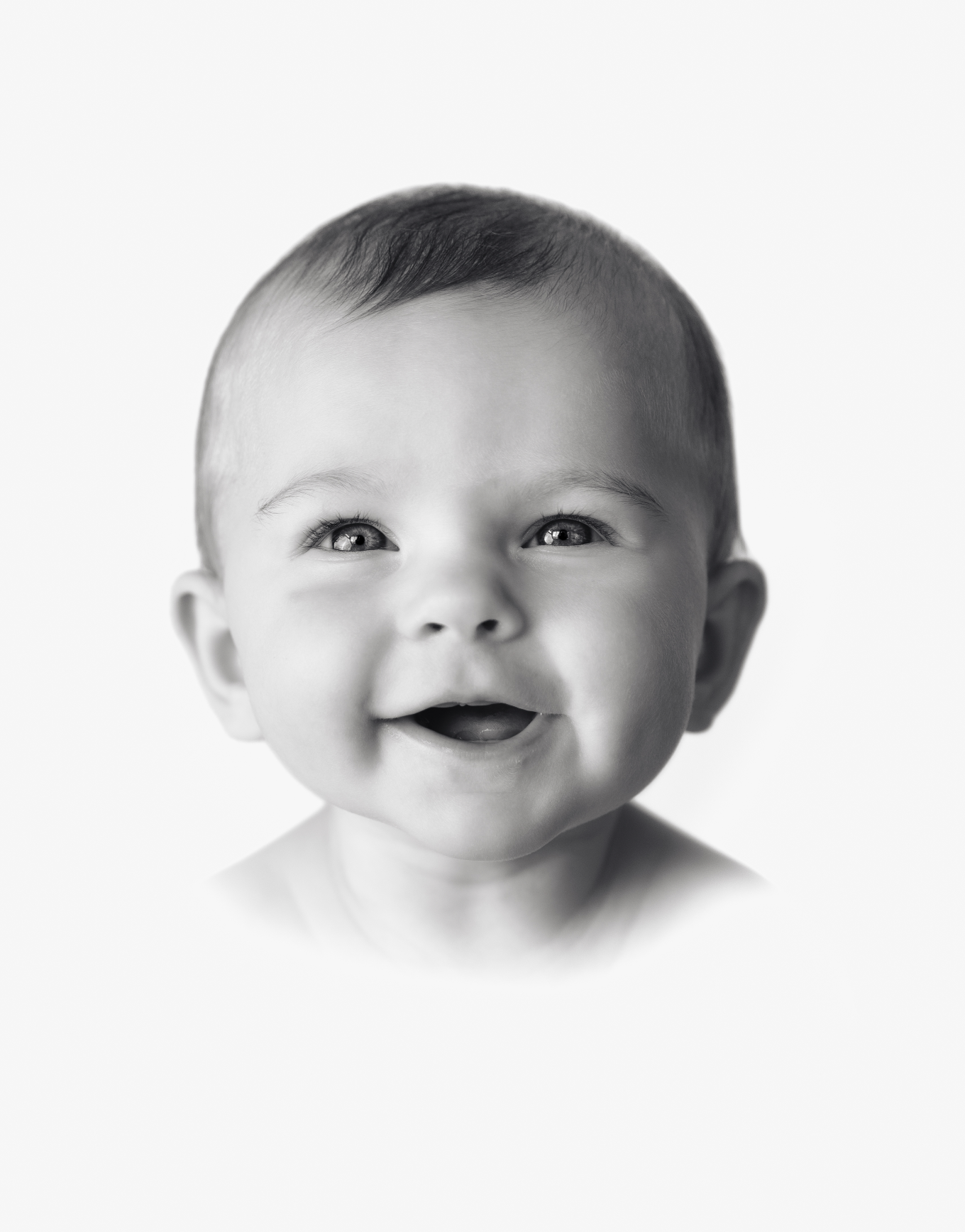 A baby sweetly smiles on her 6 month birthday in the timeless bright vignette style. 