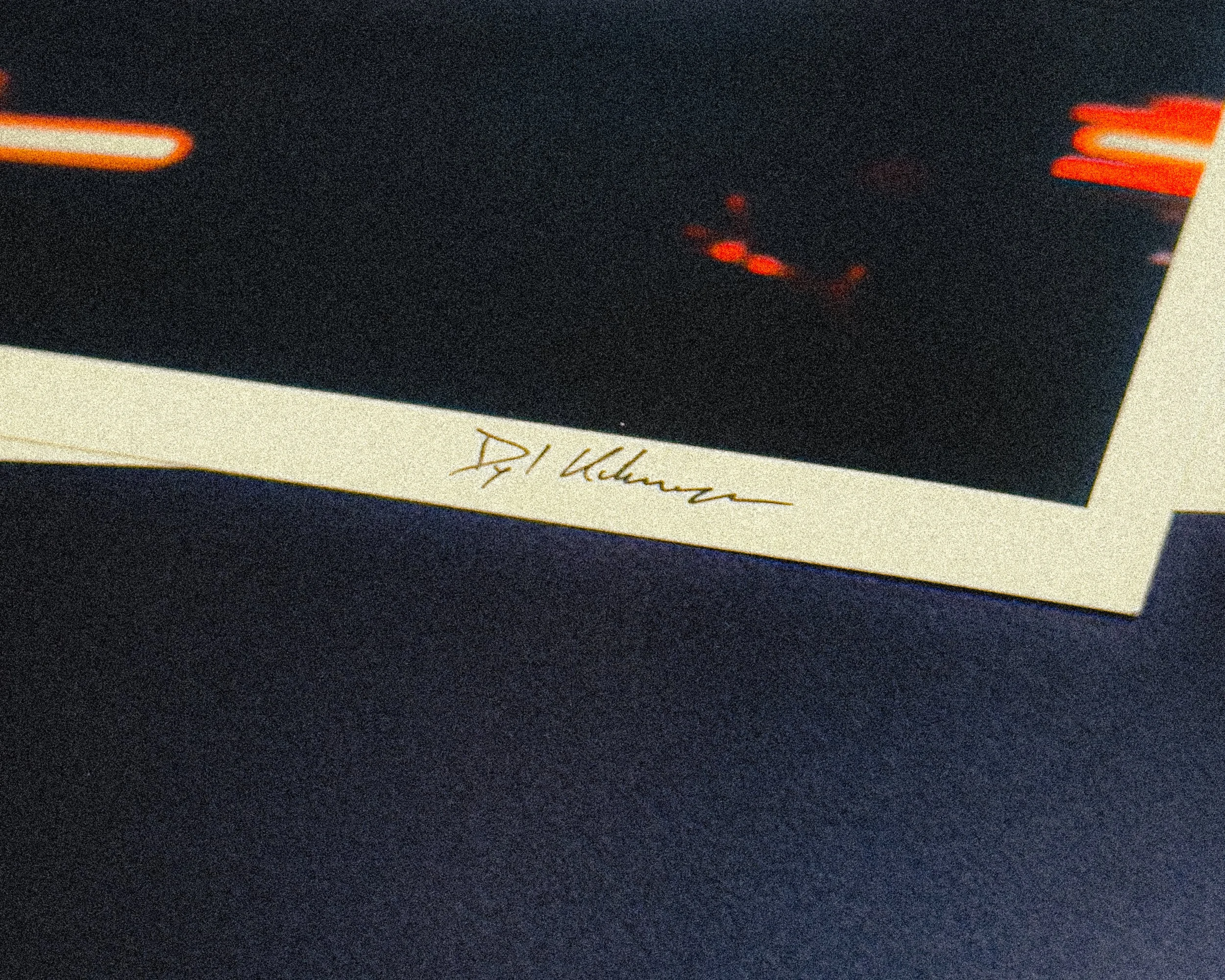 Close-up of a black object with red LED lights on it, lying on top of a white piece of paper with handwritten text.