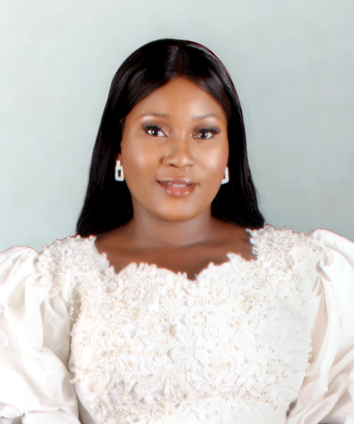 Portrait of a woman with long black hair, wearing earrings and a white embroidered blouse with puffed sleeves, against a plain background.
