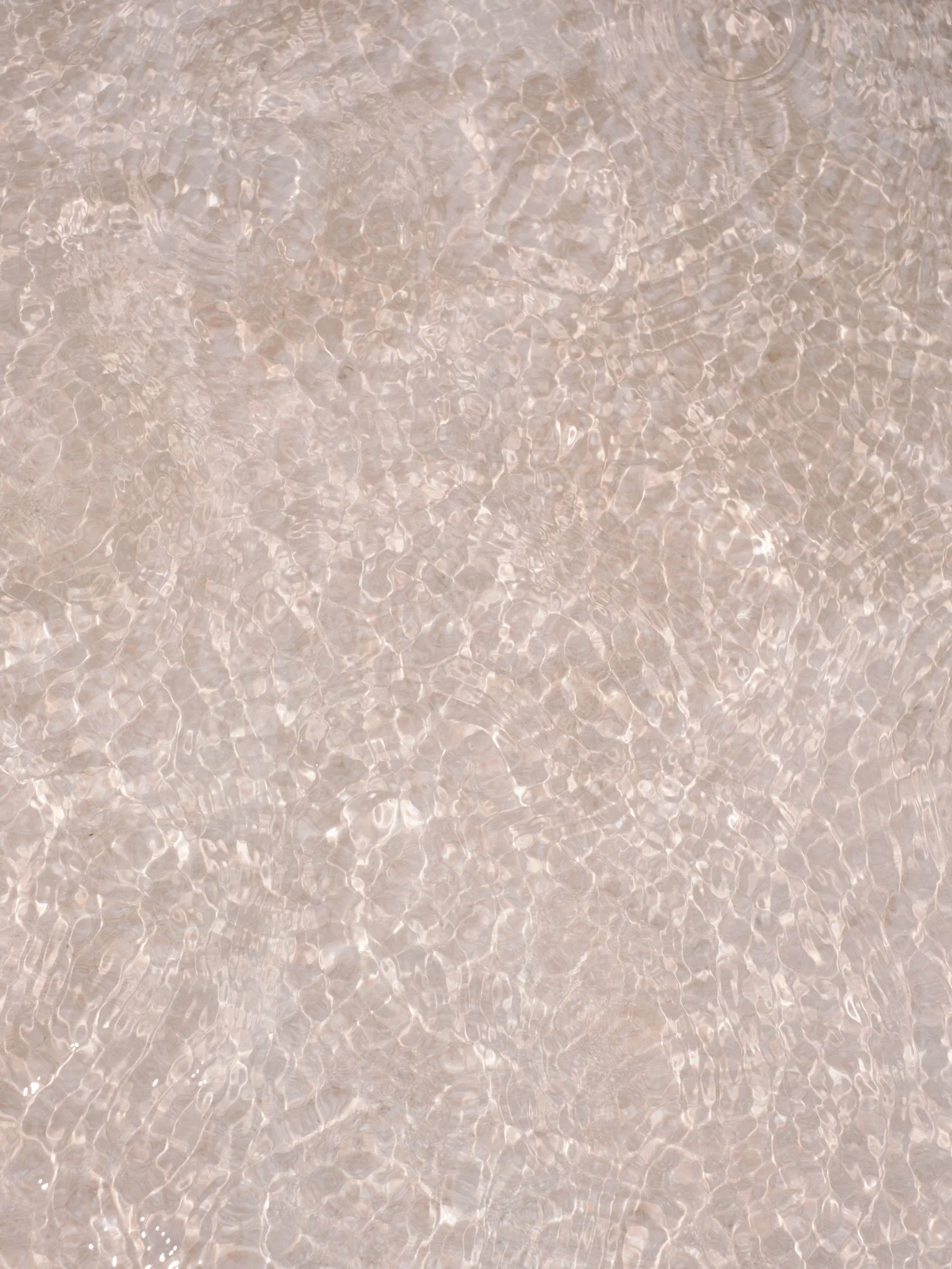 Close-up of clear water with gentle ripples and reflections.