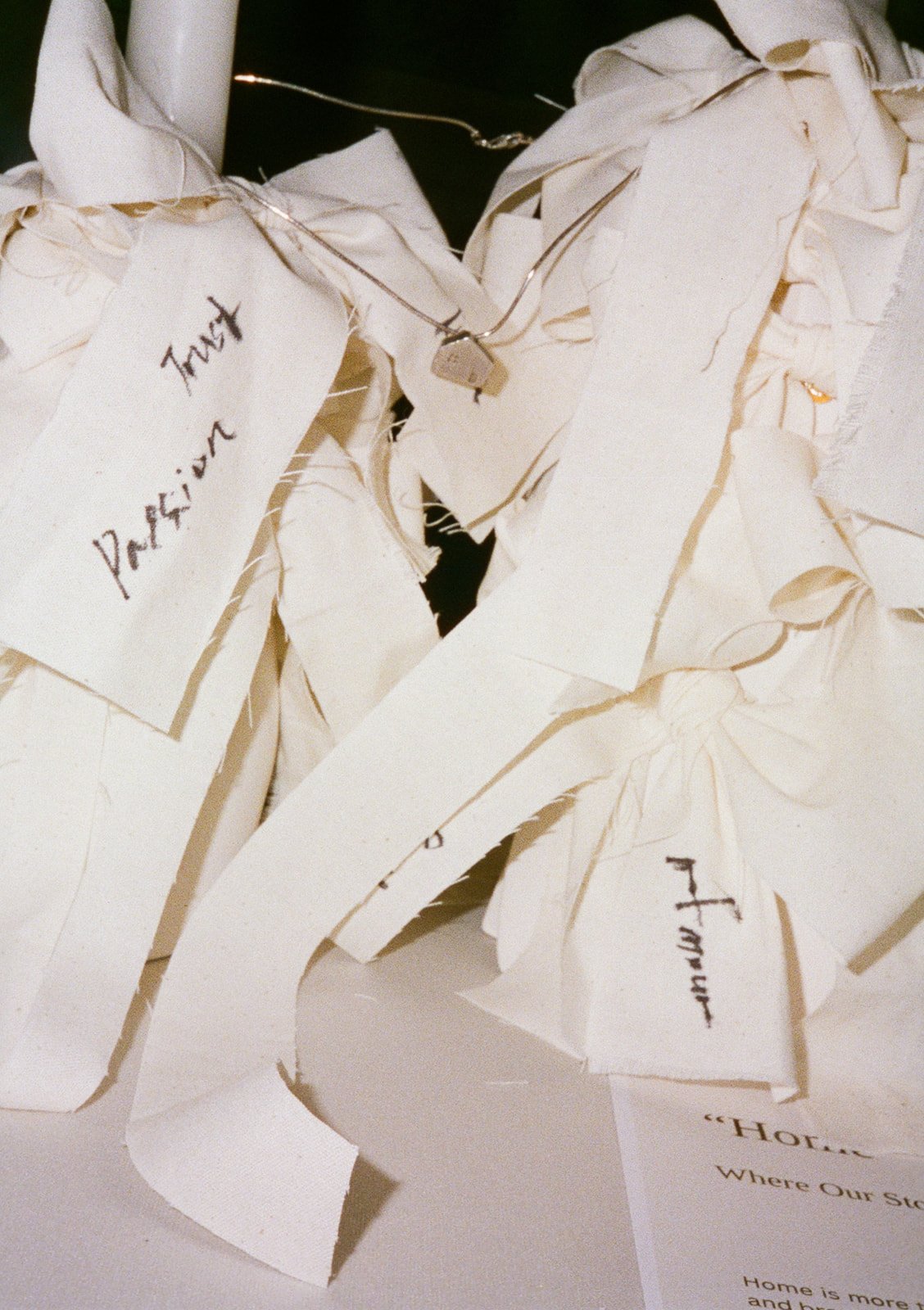 Torn pieces of paper with handwritten notes, some attached with paper clips, on a white surface.