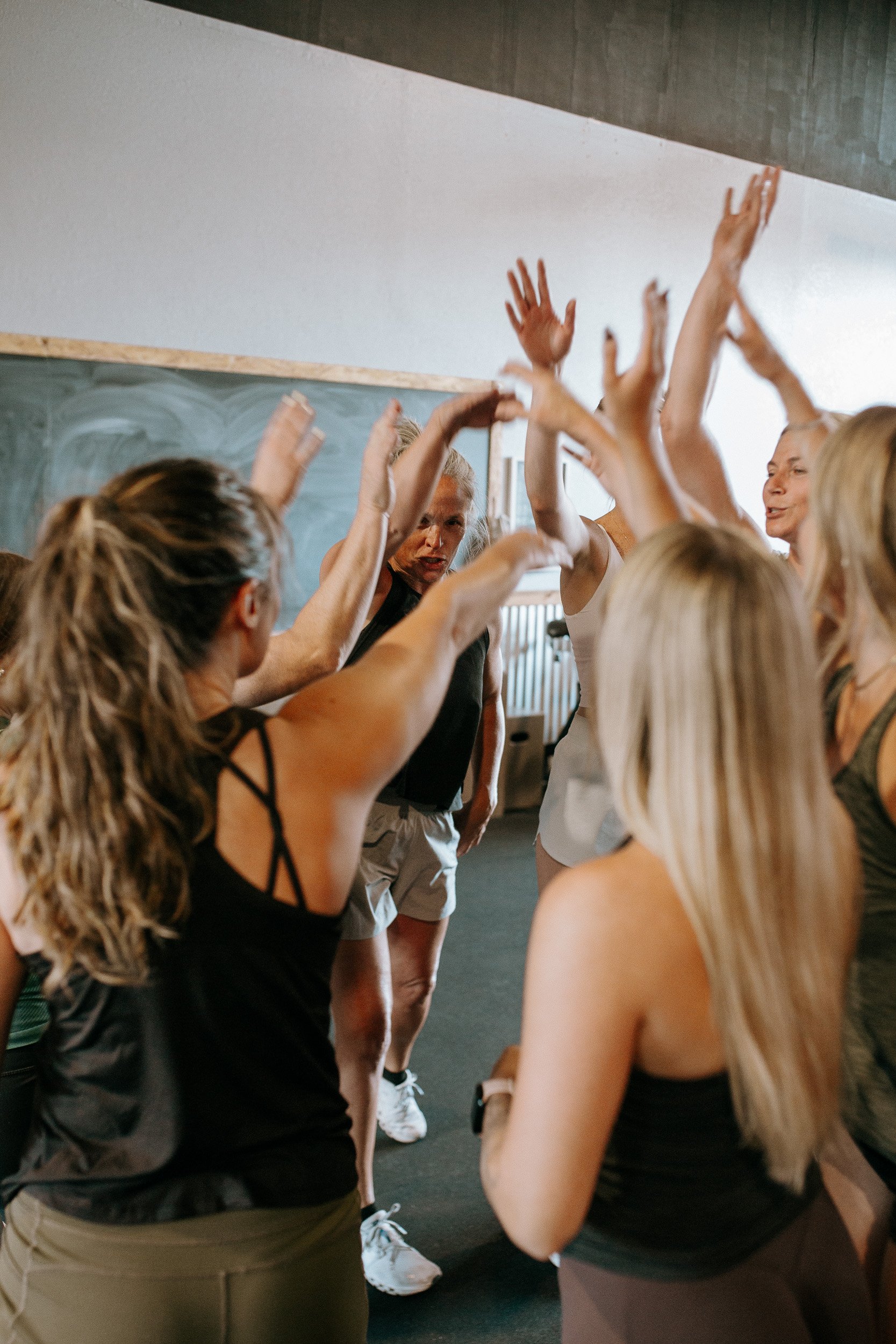 The Dropgym community of women are high fiving in excitement inside the gym in Southern Oregon.