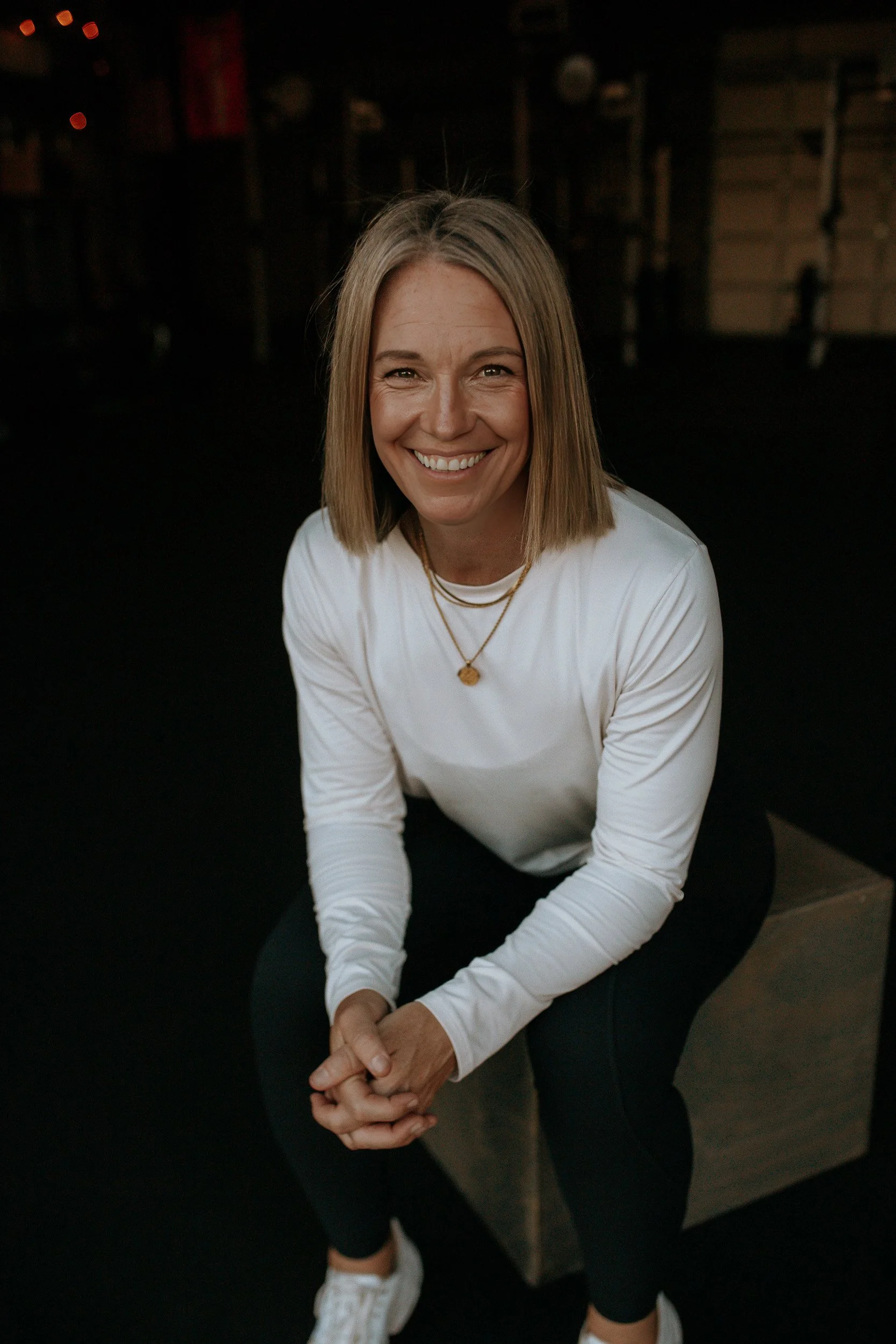Lu, co-founder of Dropgym in Medford, leaning forward and smiling.