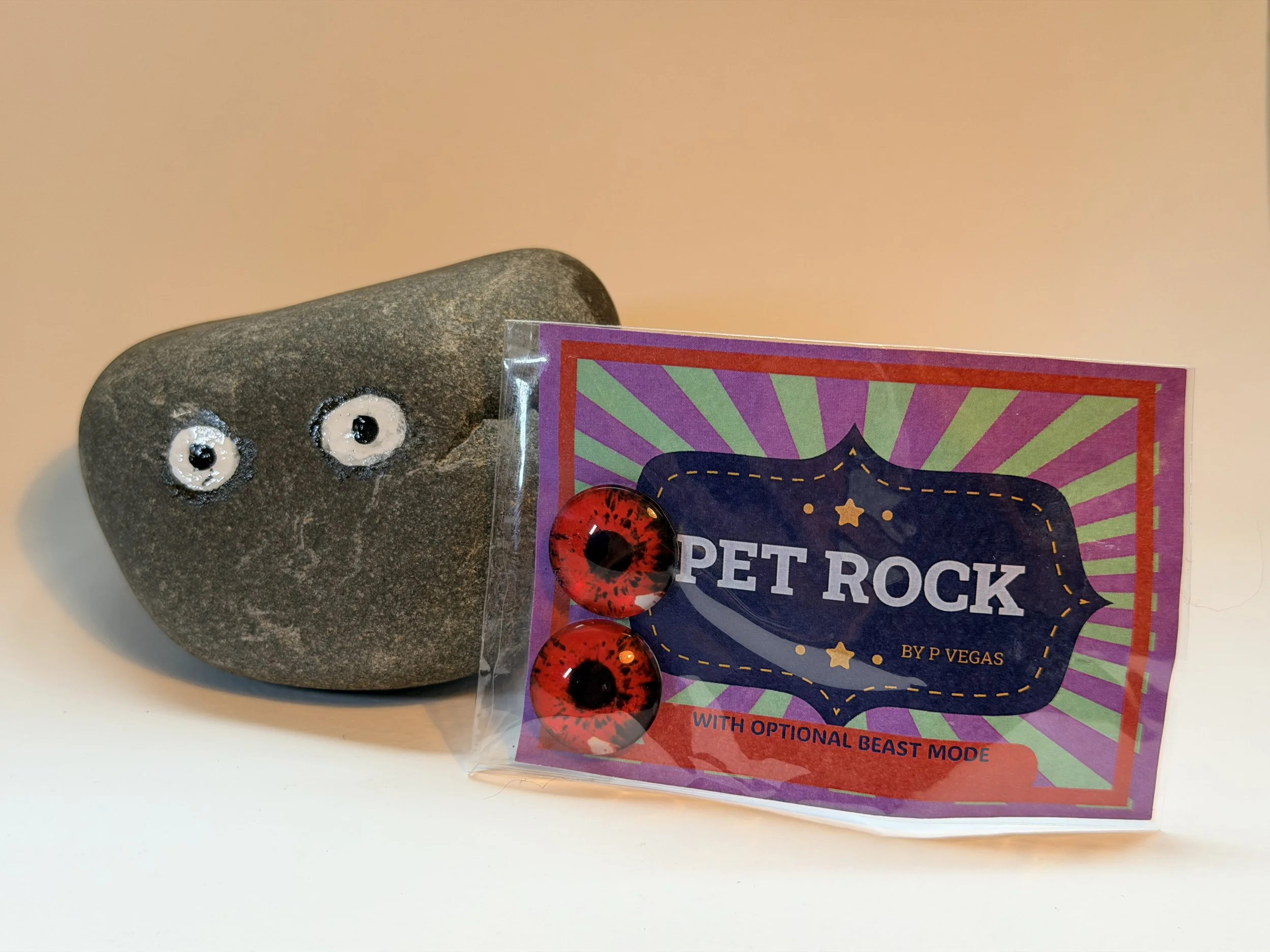 A pet rock with painted eyes and a colorful card that reads "Pet Rock" with optional beast mode stickers.