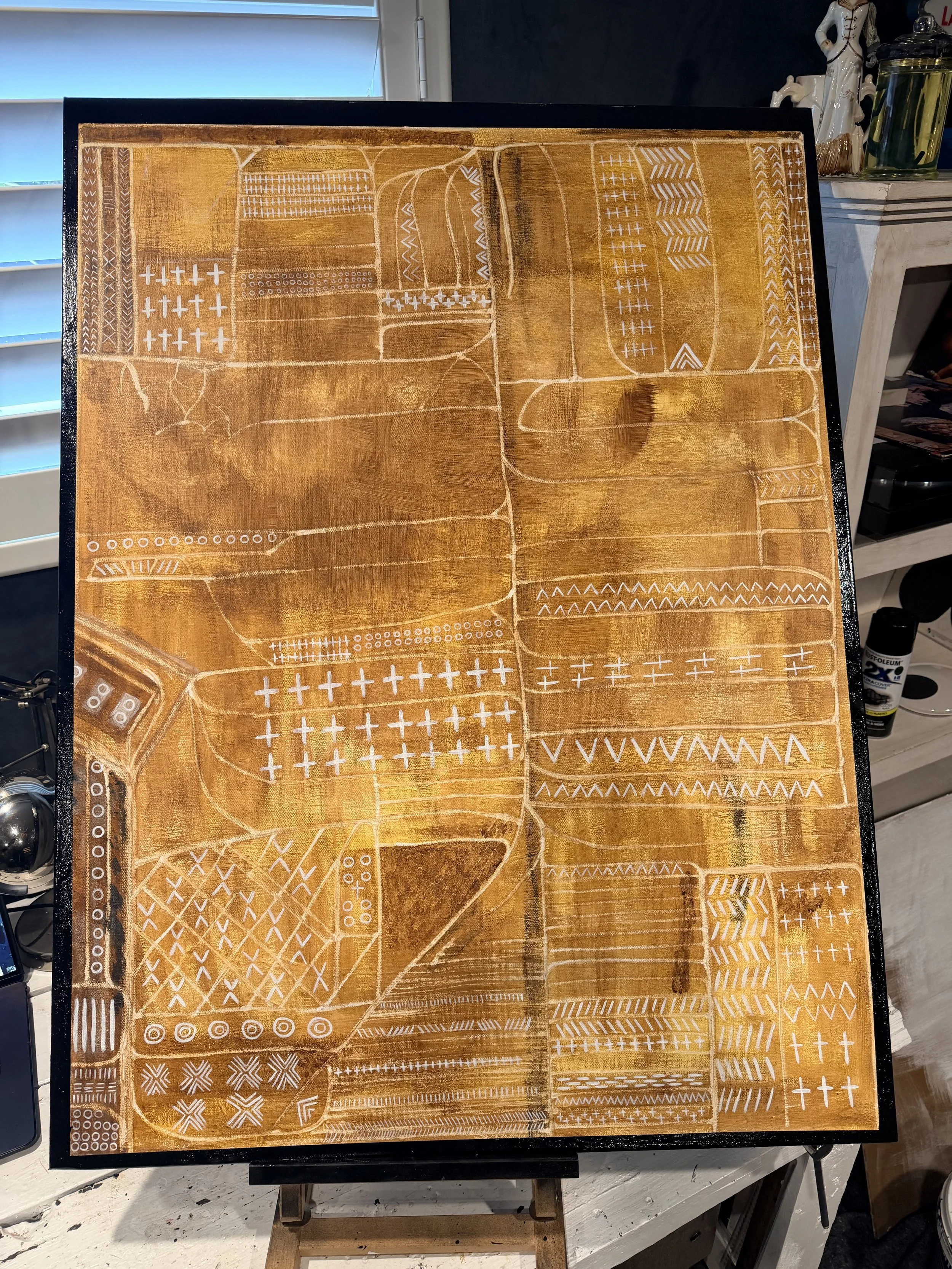 Abstract painting with a yellowish-brown background and various white geometric patterns, lines, and shapes arranged in sections.