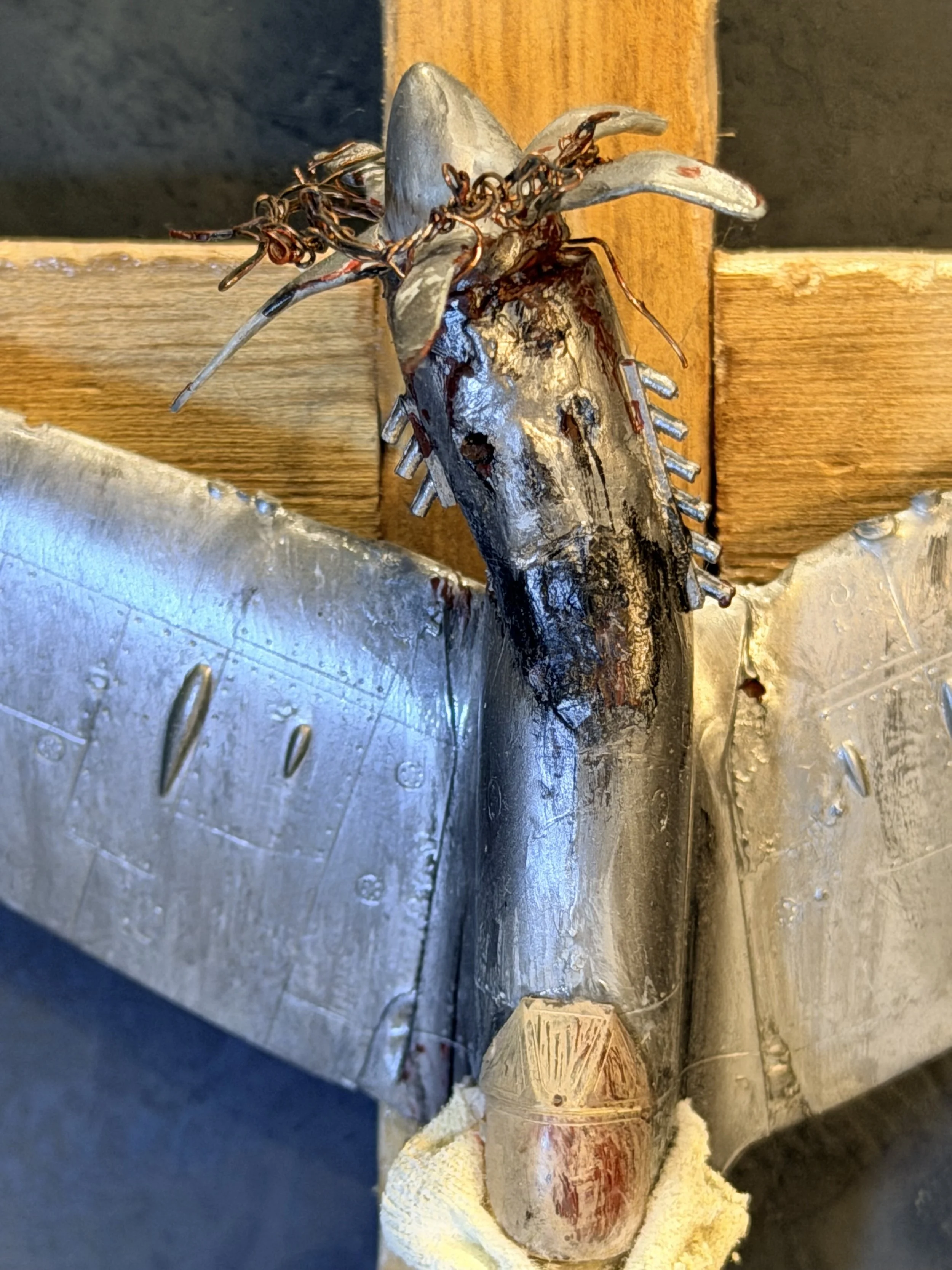A fish with a fishing hook in its mouth, lying on a work surface with tools and yellow cloth nearby.