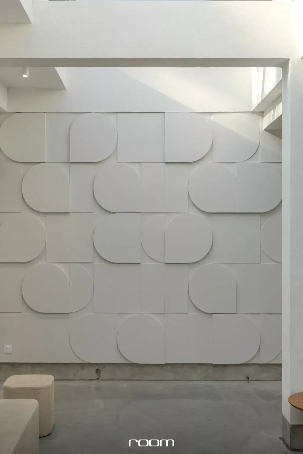 Modern interior with a textured white wall featuring 3D geometric circular and square patterns.