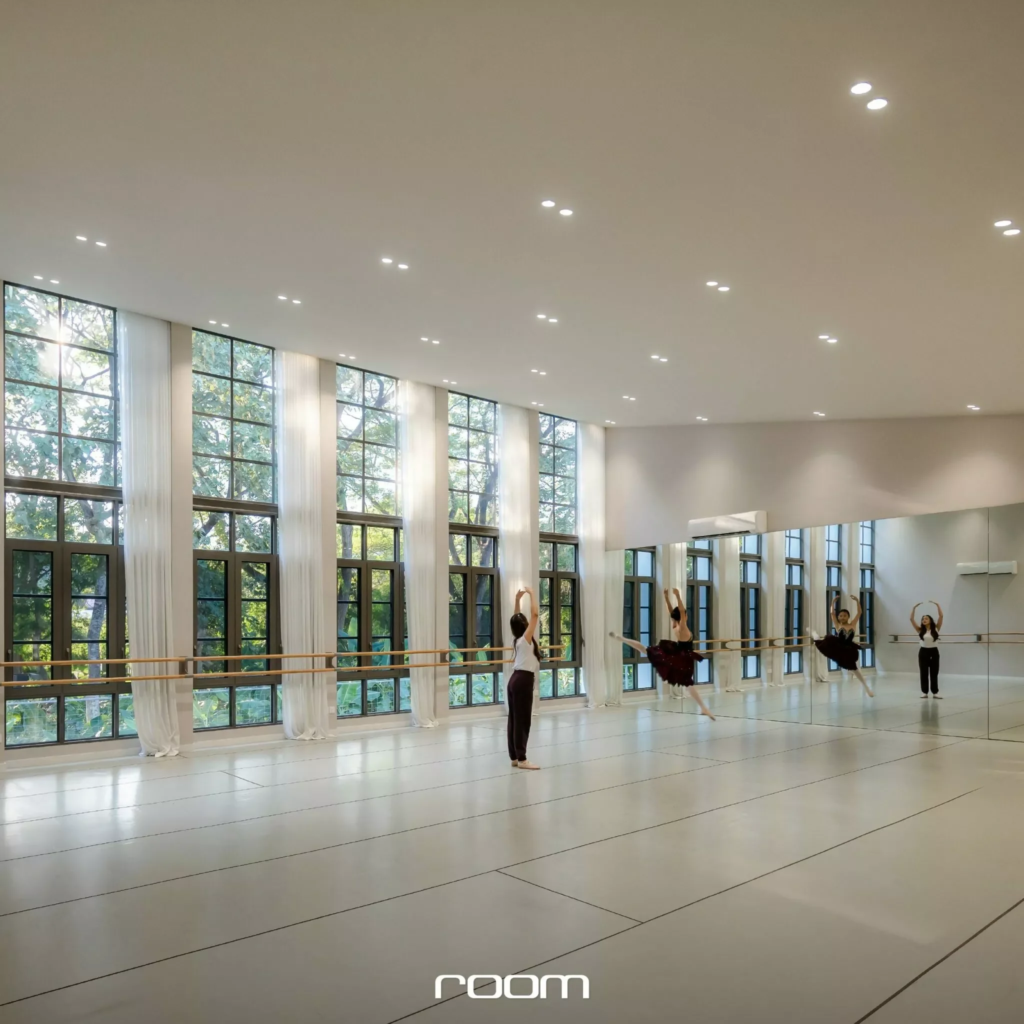 A spacious dance studio with large windows, white curtains, and dancers practicing ballet or contemporary dance, guided by an instructor.