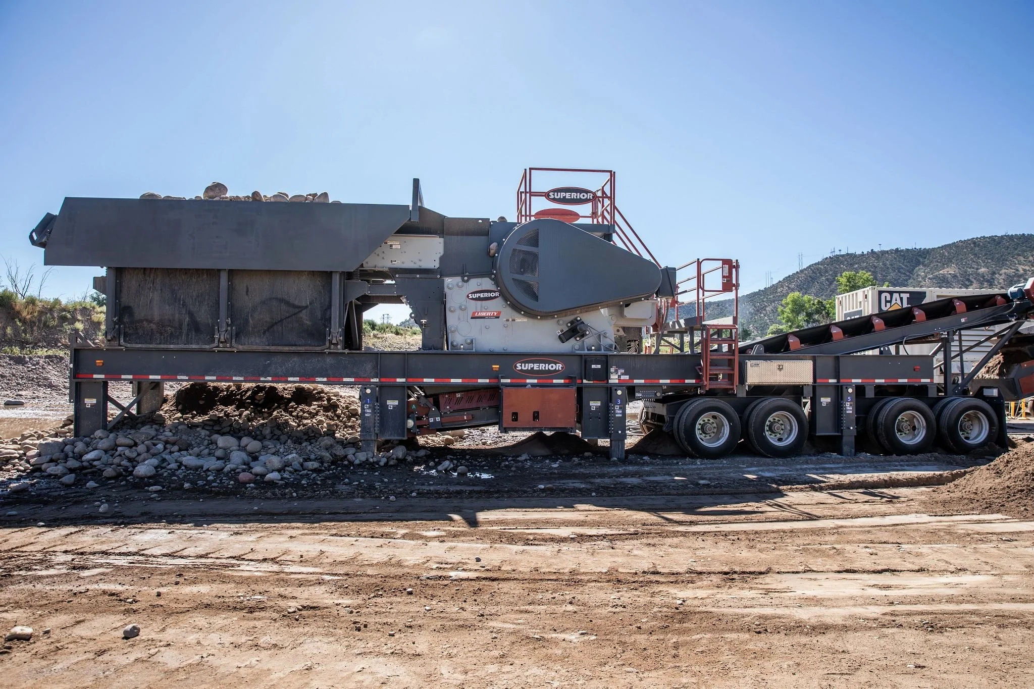Superior mobile rock crusher and conveyor at a gravel quarry
