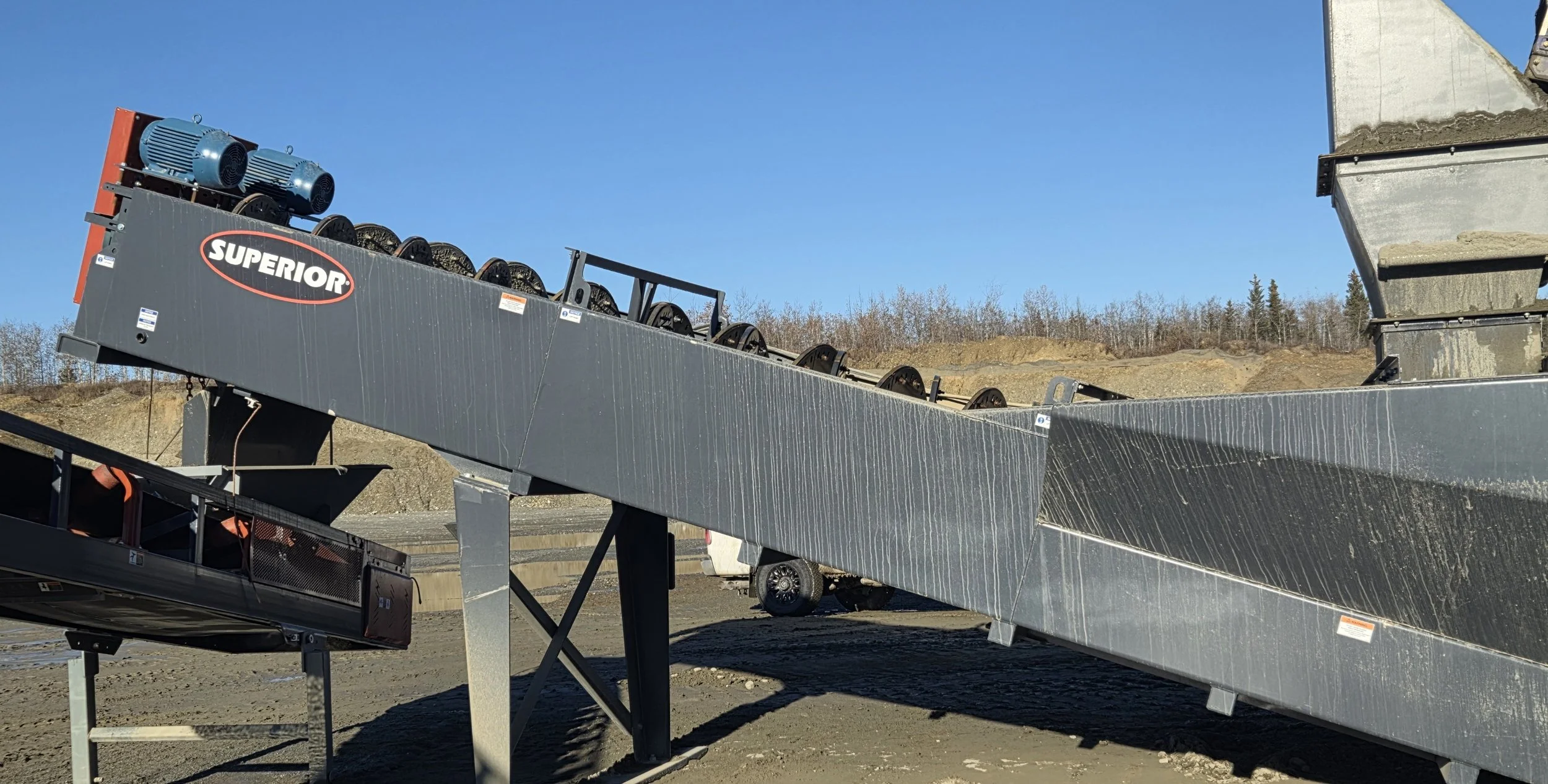 Superior industrial conveyor system with electric motors and rollers at an outdoor aggregate processing site