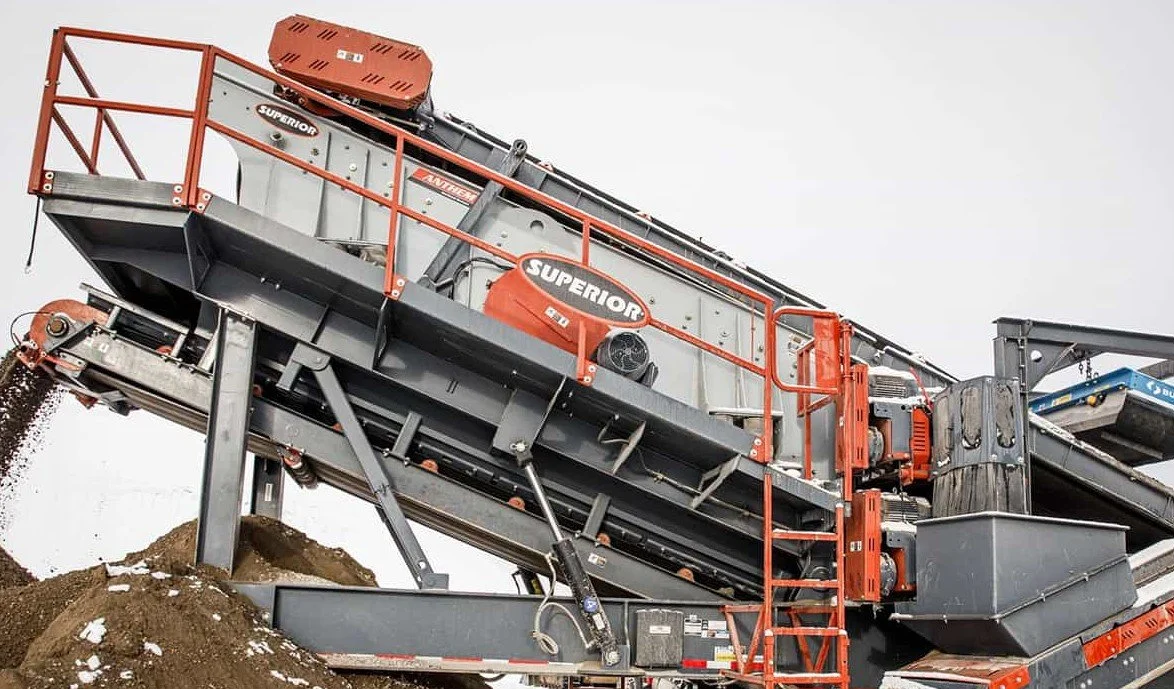 Superior Industries aggregate screening machine processing a pile of gravel at a construction site