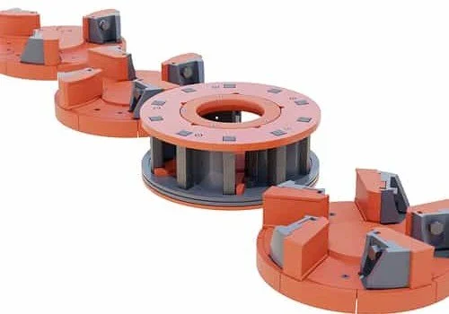 Orange industrial electrical transformer windings with copper coils and gray insulating components
