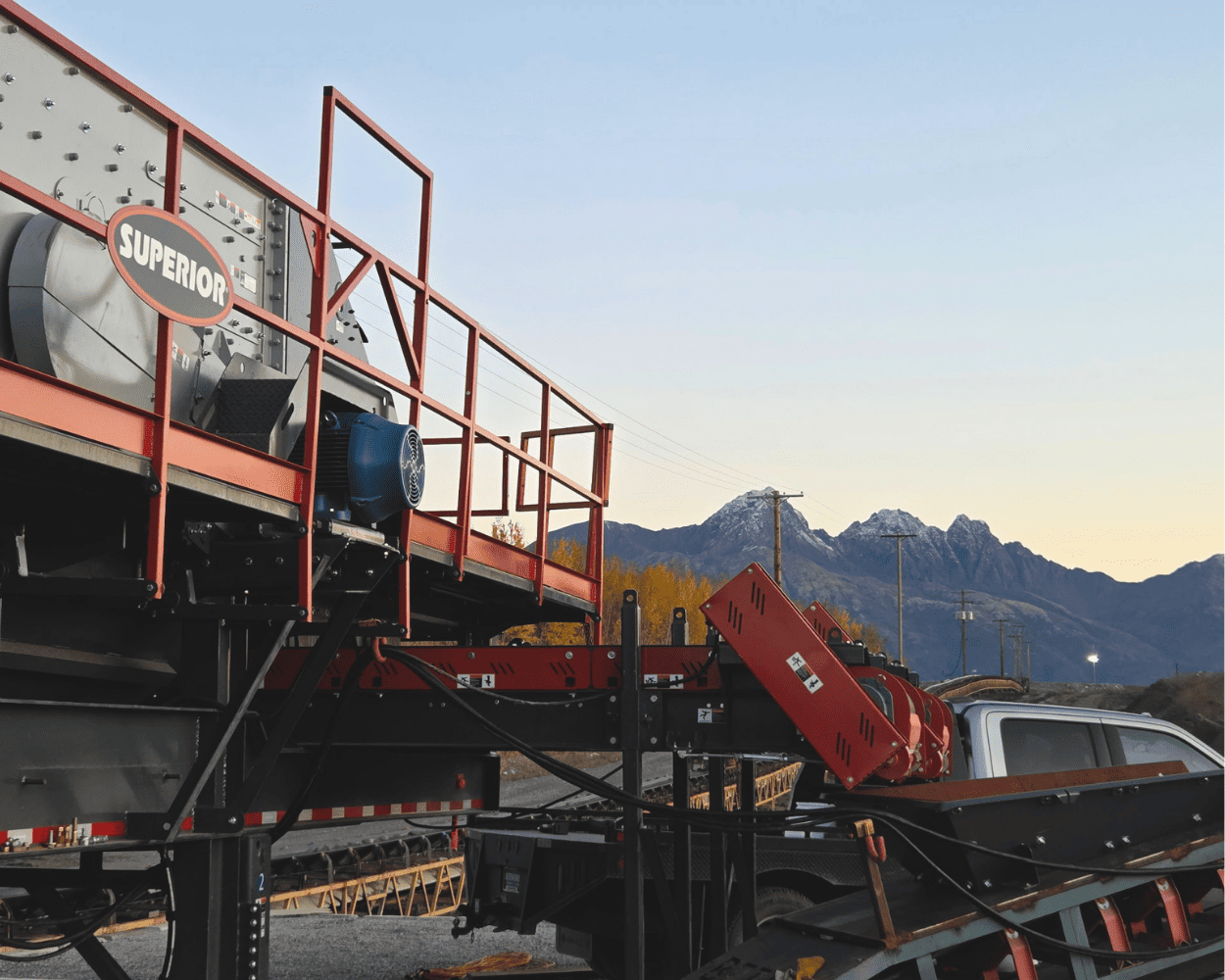 Superior-branded industrial trailer with red safety rails parked against a mountain backdrop