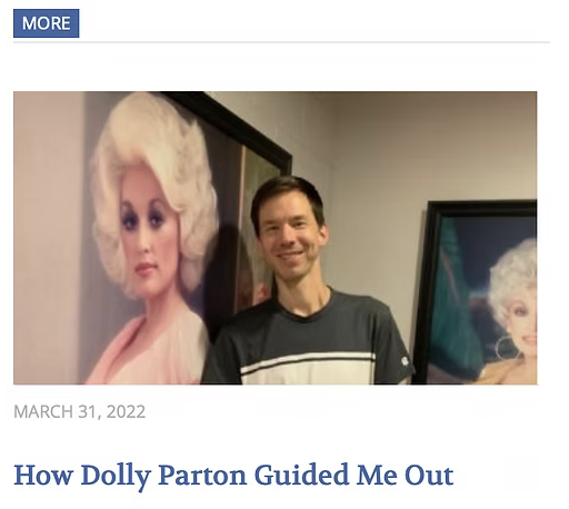 A smiling man standing indoors next to two framed portraits of Marilyn Monroe.