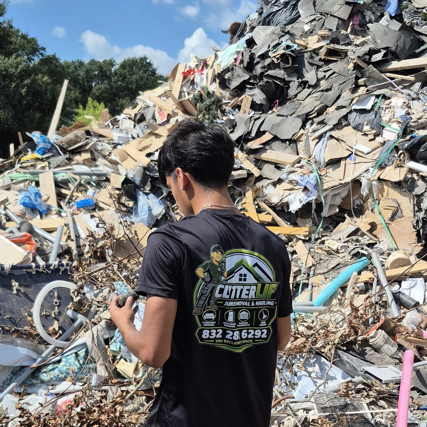 Ricky from ClutterLift junk removal in Pasadena, TX, wearing a ClutterLift shirt on the job