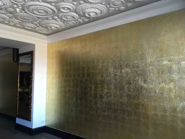 Interior wall painted gold with ornate ceiling detailing and decorative molding.