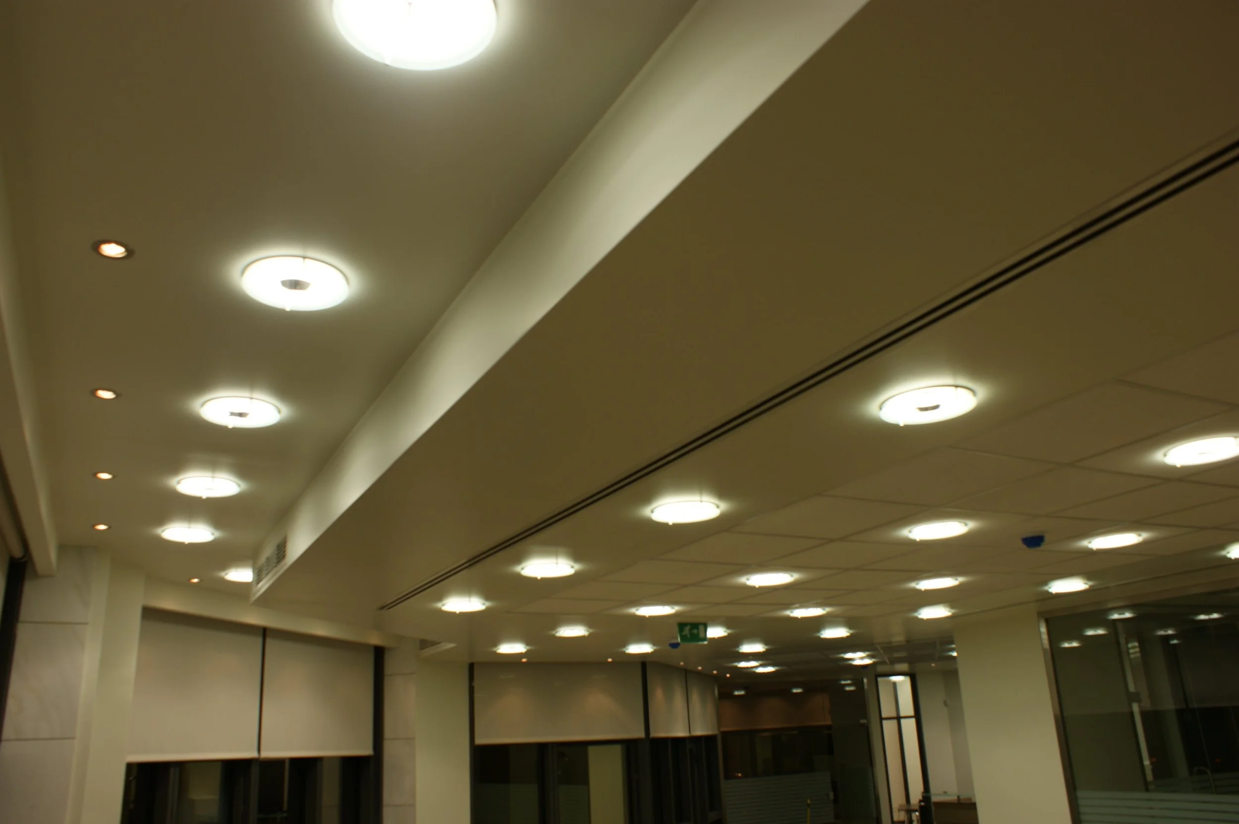 Ceiling lights in an indoor space, with a curved ceiling and some visible doorways or partitions.