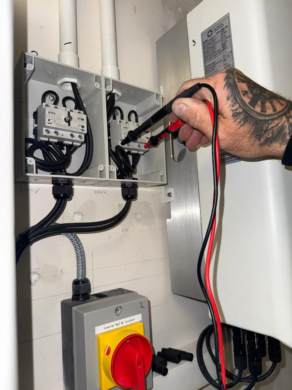 Electrician testing an electrical panel with a multimeter.