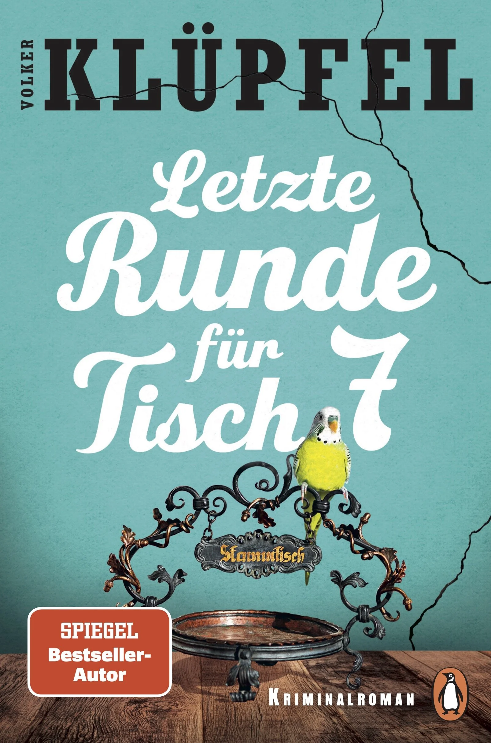 Book cover with a turquoise background featuring a decorative birdcage with a yellow budgie perched inside, and a cracked wall detail. The title is in German, reading 'Letzte Runde für Tische', with the name 'Klaus-Peter Wolf' at the top, and a red sticker indicating 'SPIEGEL Bestseller-Autor'. The publisher's penguin logo is at the bottom right.