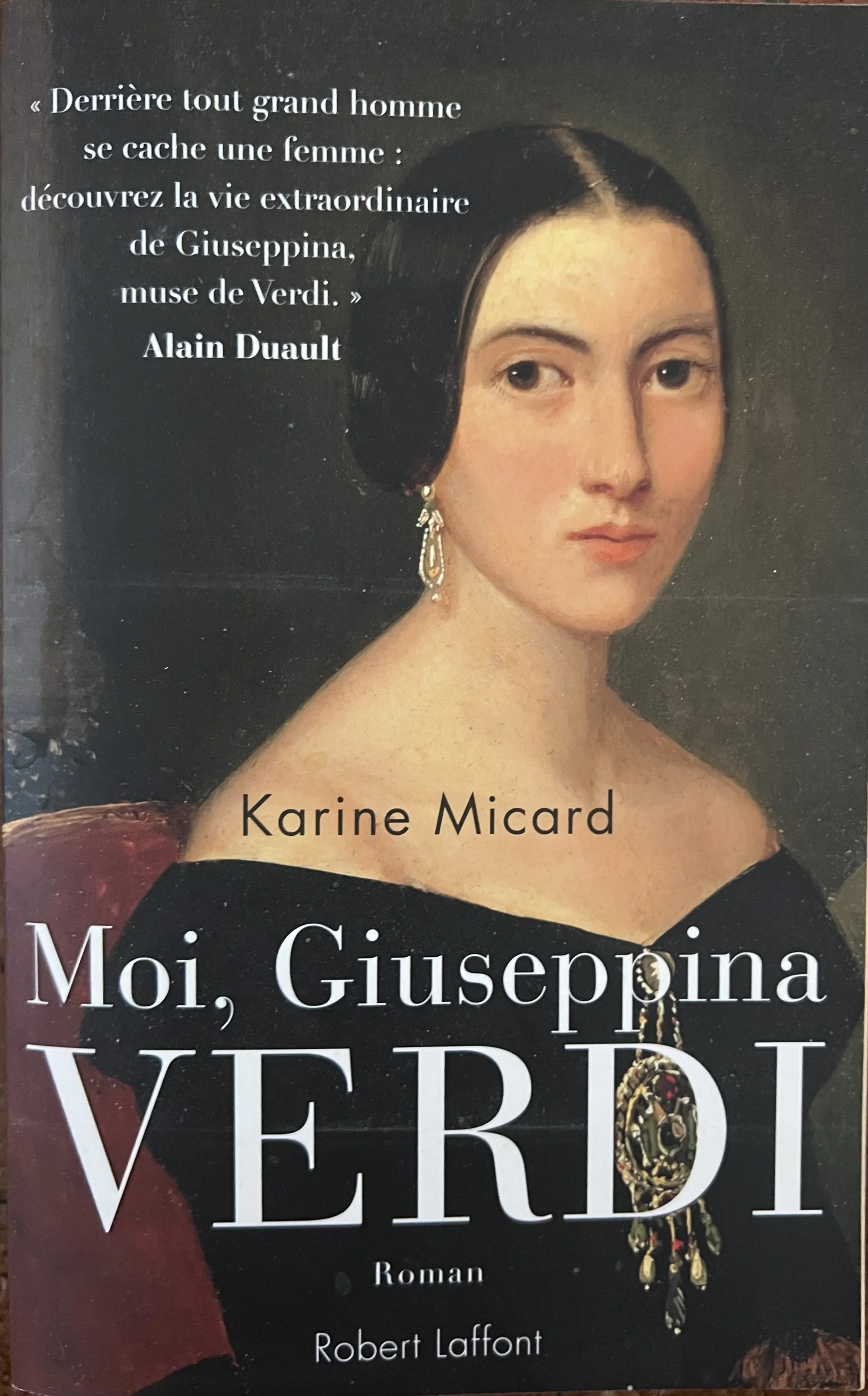 Couverture de livre avec portrait d'une femme aux cheveux noirs, portant une robe noire et des bijoux, et texte en français.