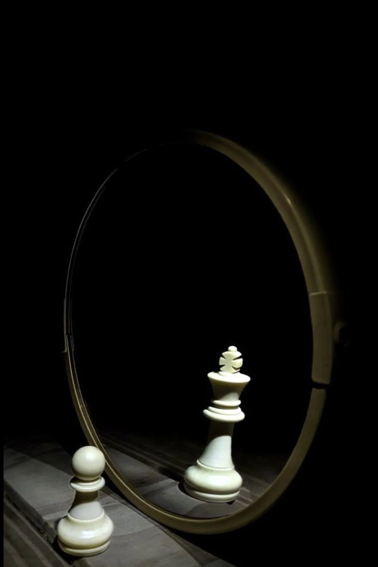 Une scène d'échecs miniature avec une pièce de roi, reflétée dans un miroir rond, avec un décor sombre.