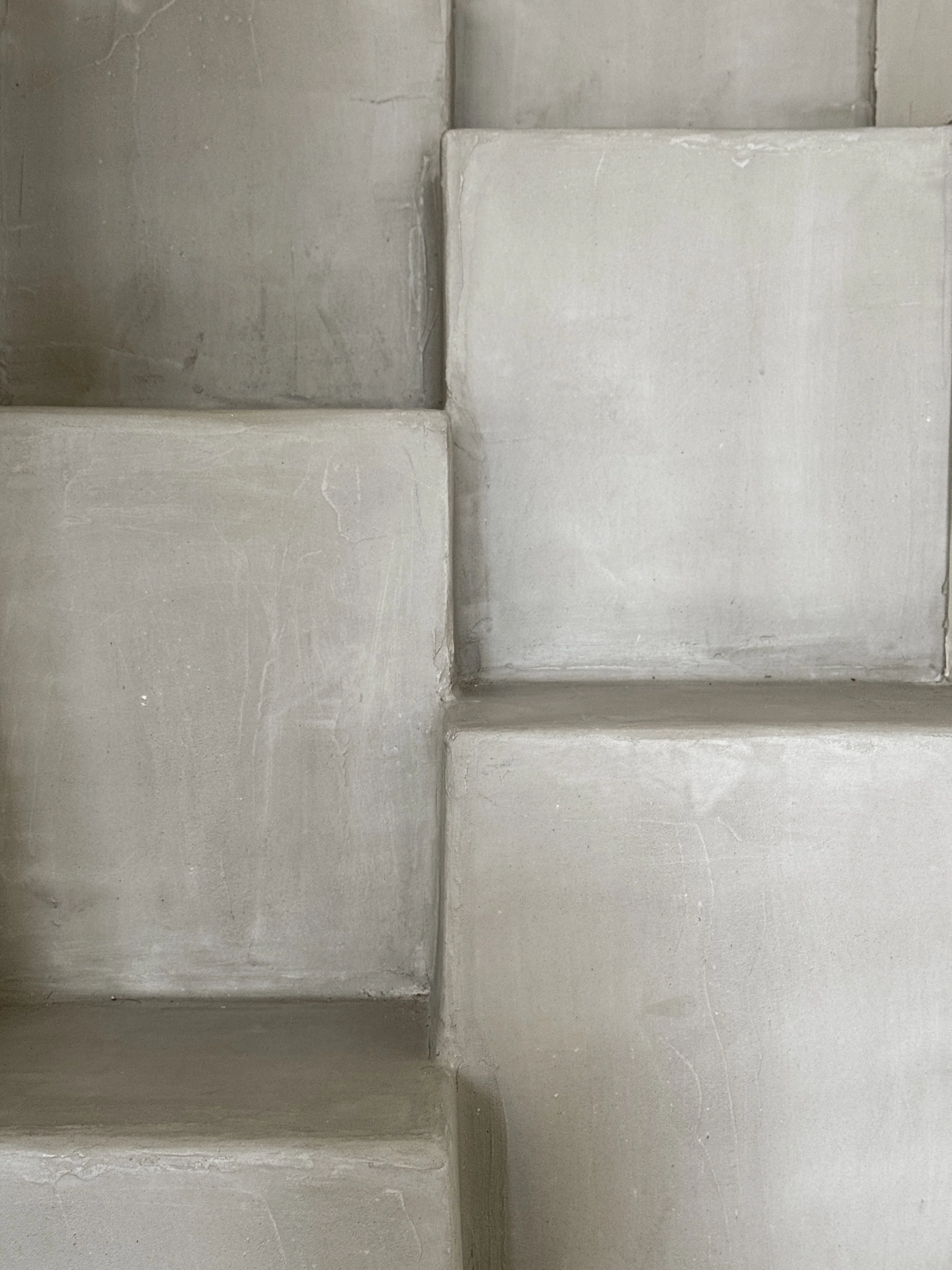 Close-up of white, textured concrete stairs with visible edges and surface imperfections.