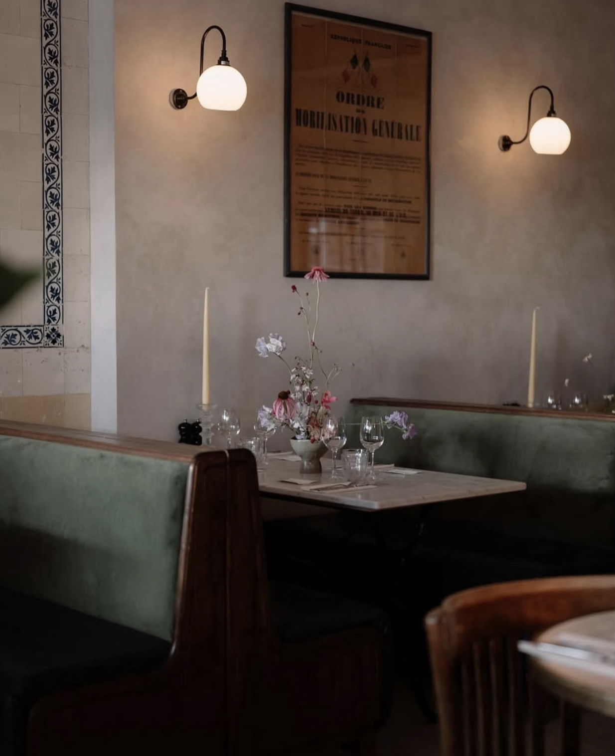 Interior of a beautiful dining room at Patron restaurant with handmade wood, leather and velvet booths, marble tables, period features, intricate decorations, candles and soft lighting.