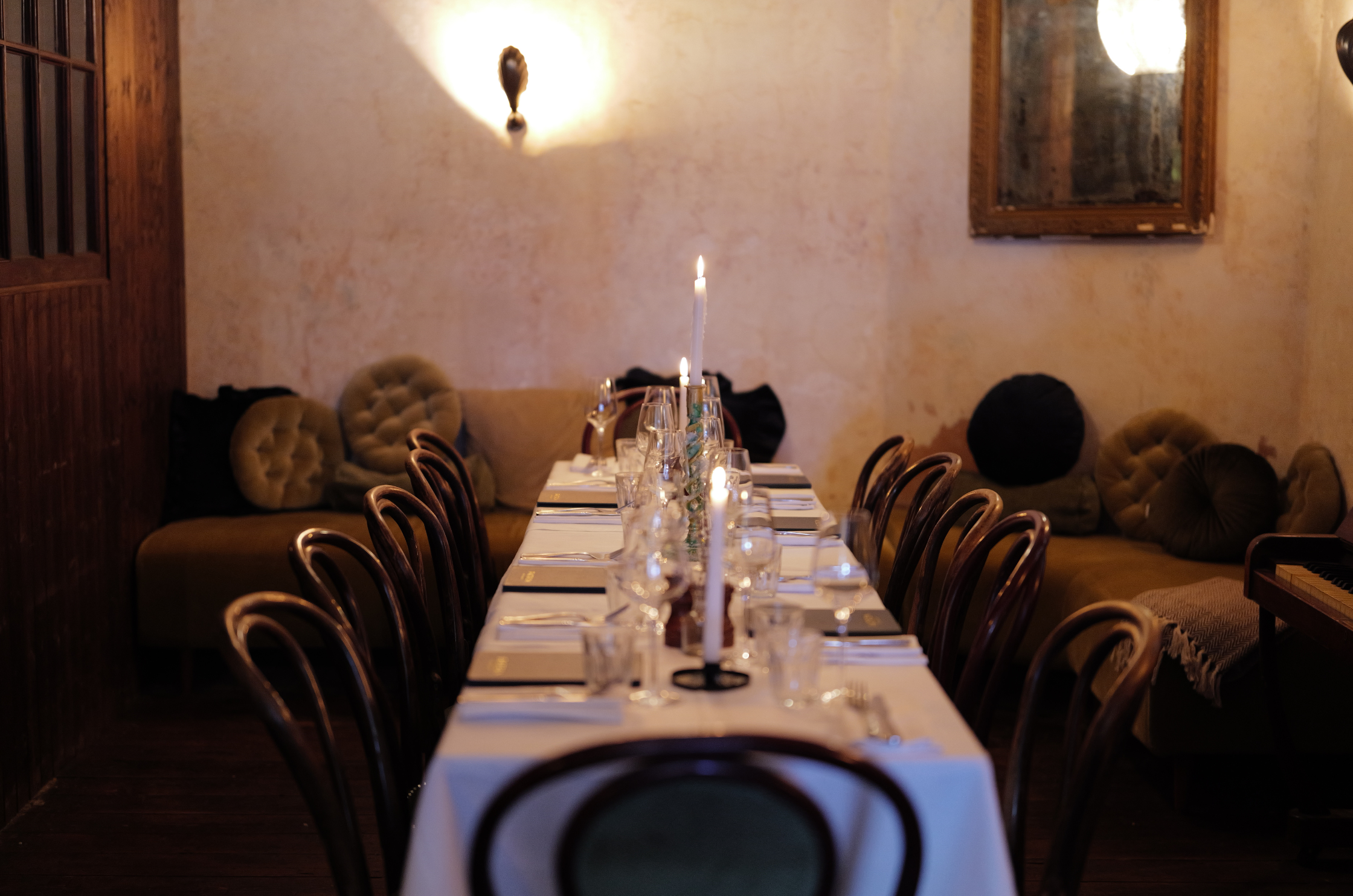 Intimate private dining experience at the Spirit Lounge at Patron, a long dining table, beautifully set with white tablecloths, glasses and candles.