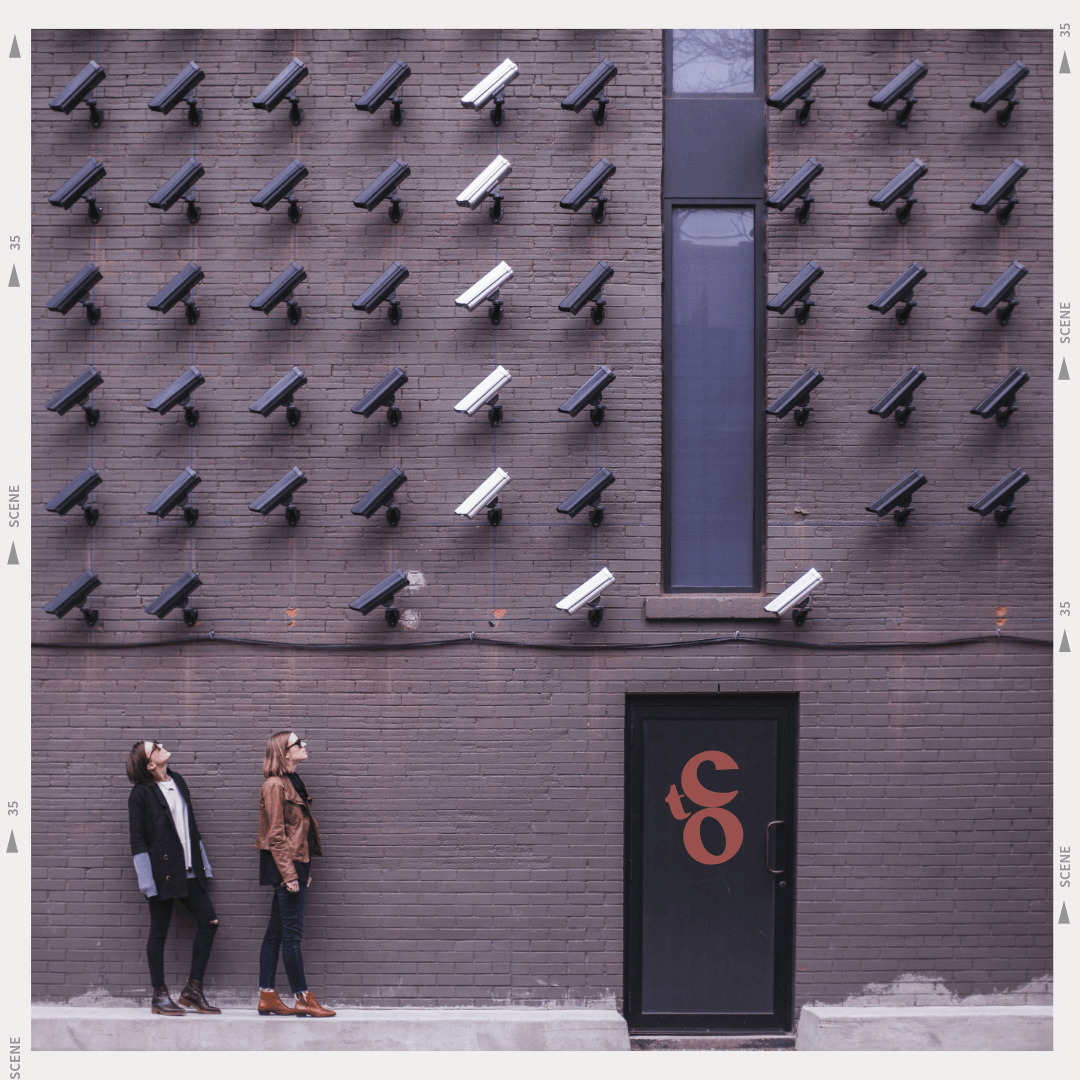 Two women staring at surveillance cameras