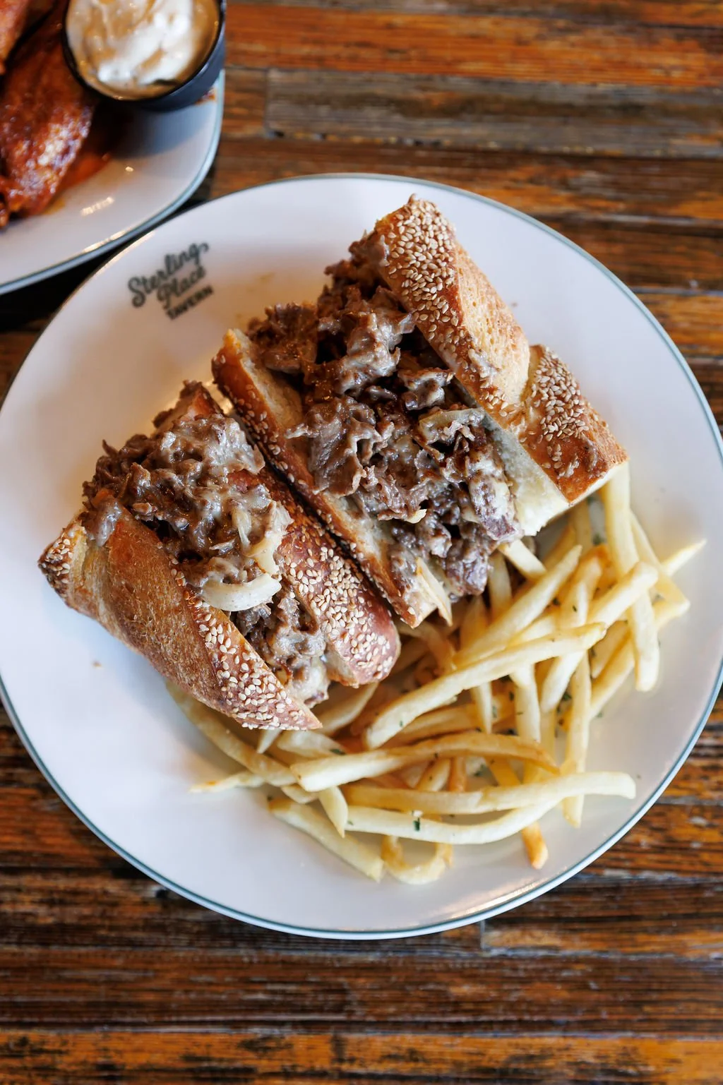 Buffet plate with meat-filled stuffed bread and French fries, on a wooden table