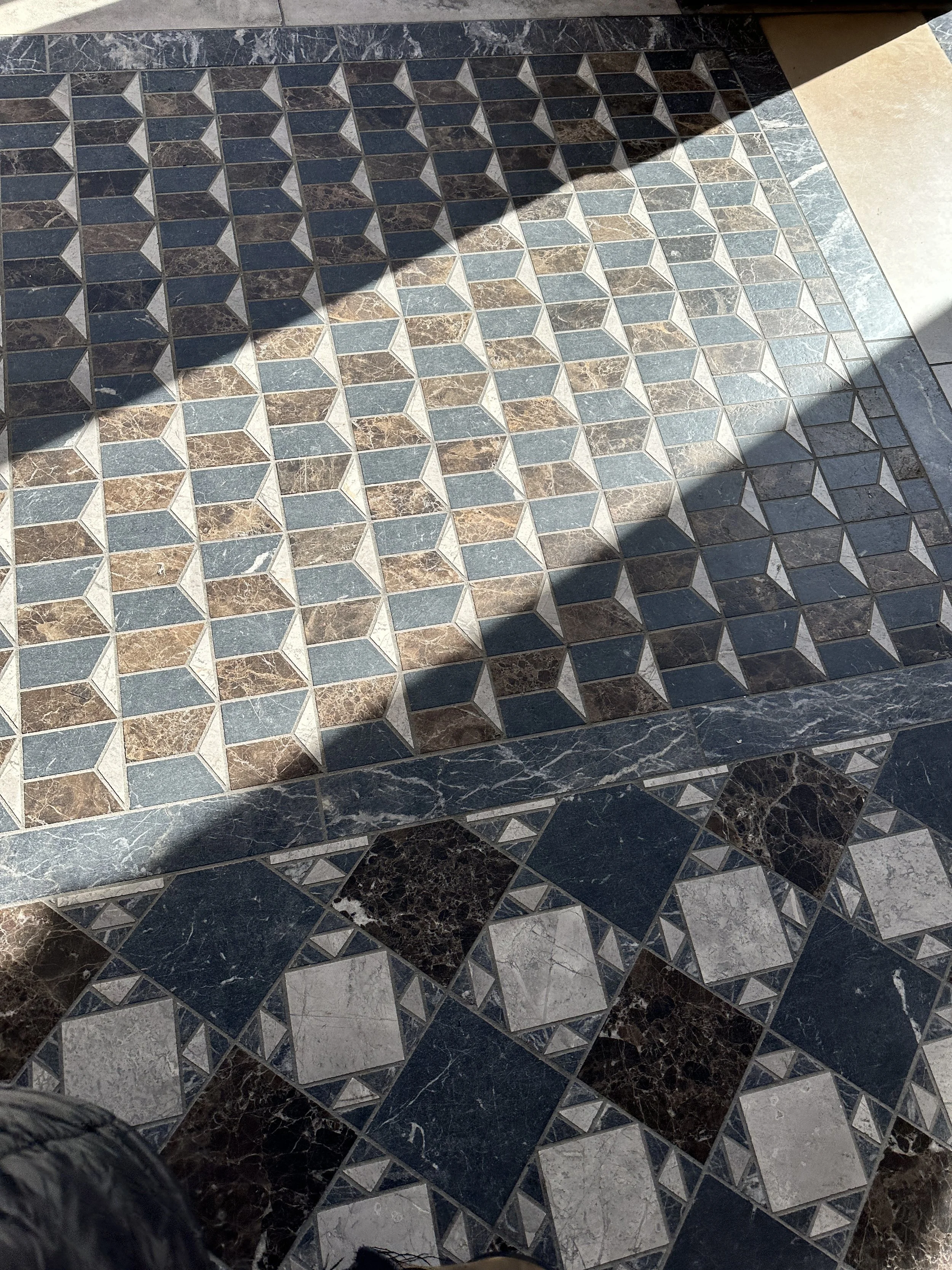 Patterned stone and mosaic flooring with layered geometric designs.