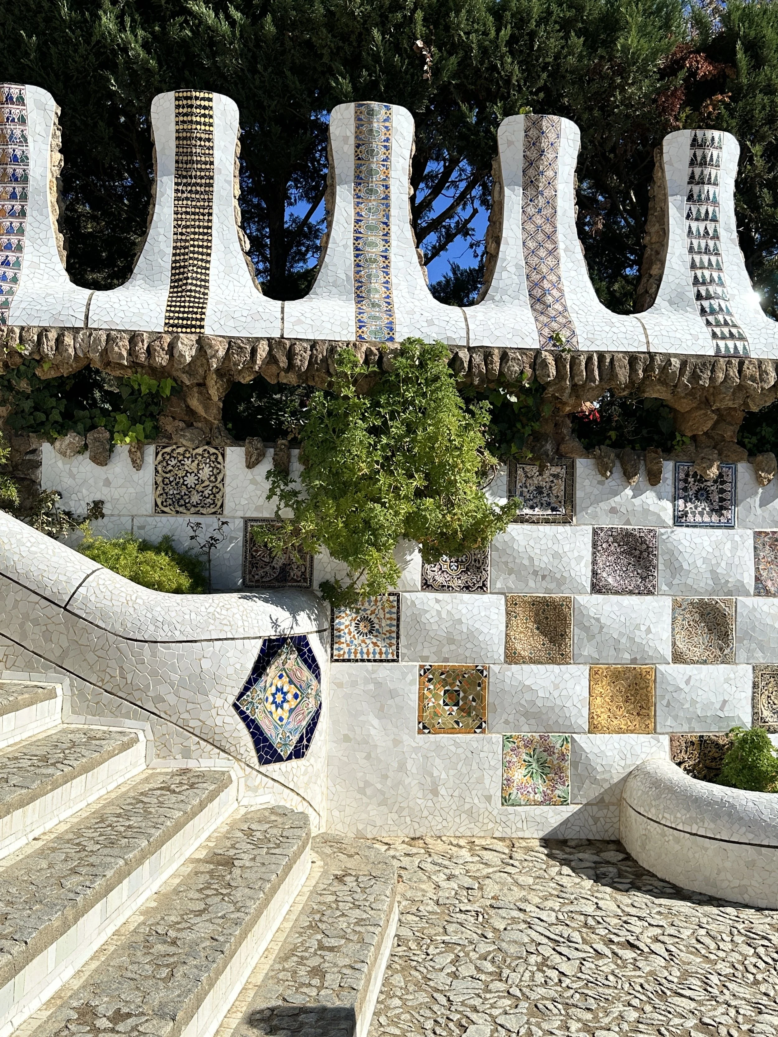 Sculptural mosaic courtyard with patterned tile, curved architectural forms, and decorative surfaces.
