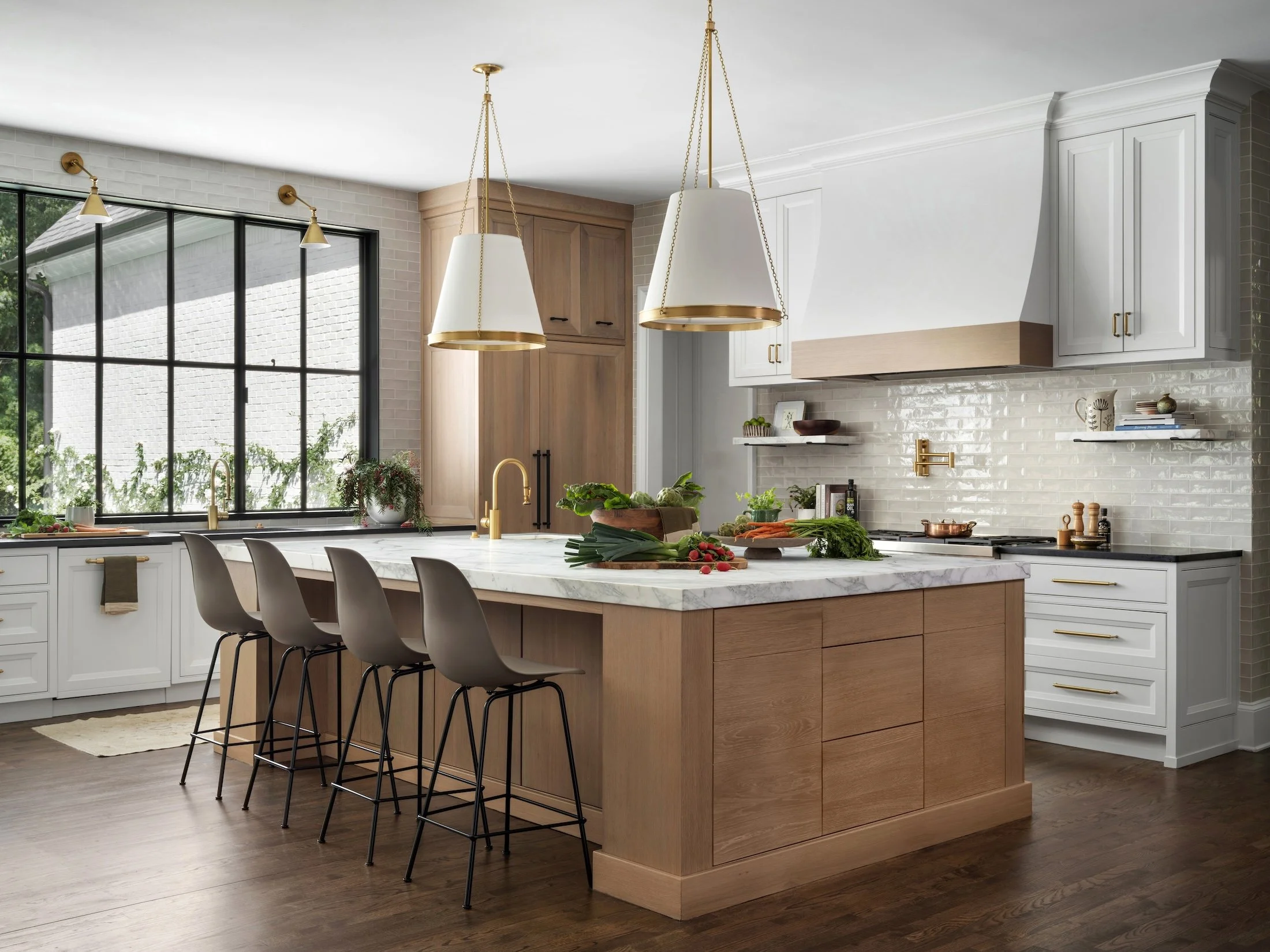 Custom kitchen with a large wood island, white cabinetry, pendant lighting, and surrounding windows.