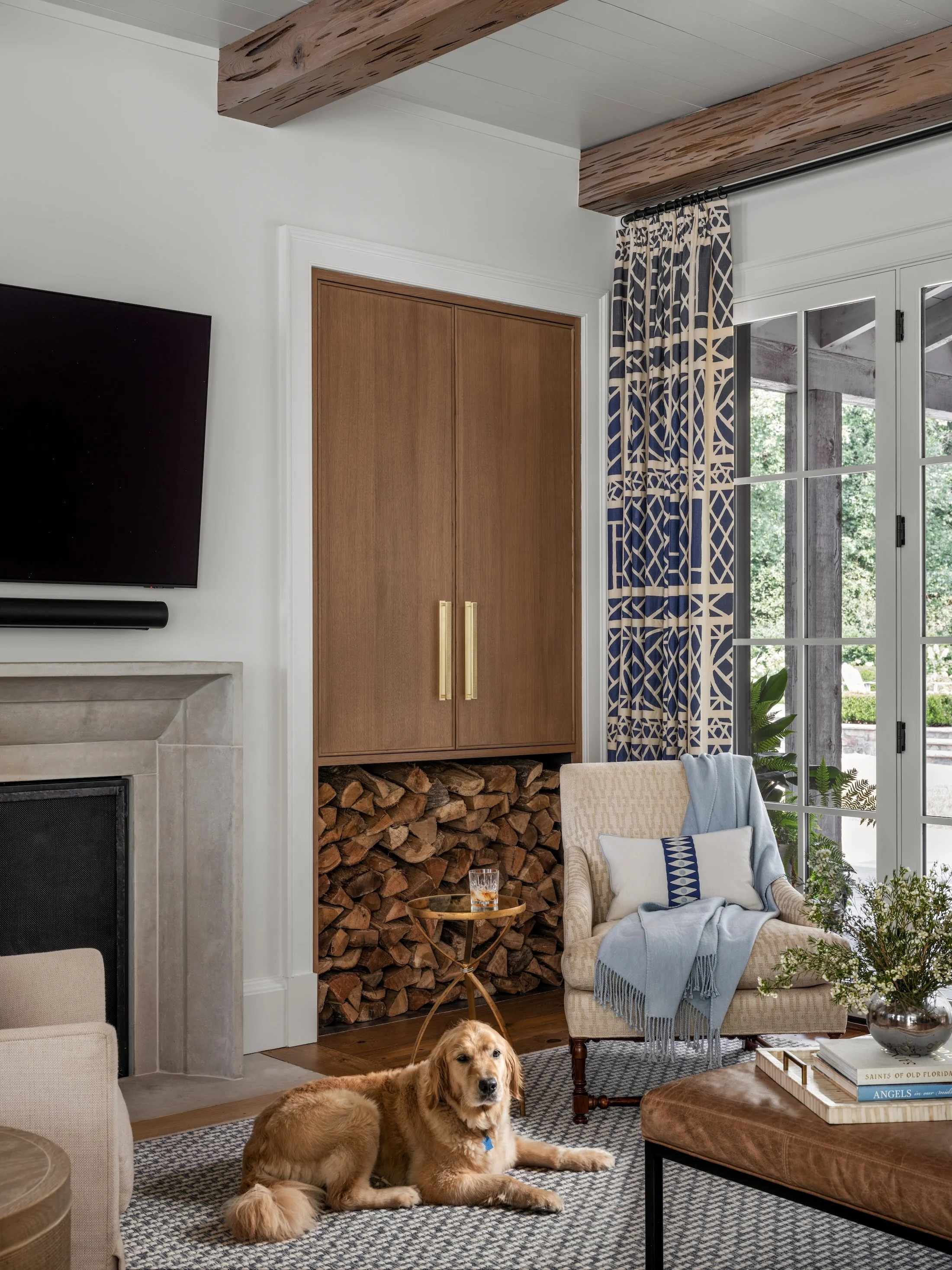 Living room with a fireplace, built-in wood storage, patterned textiles, and layered furnishings.