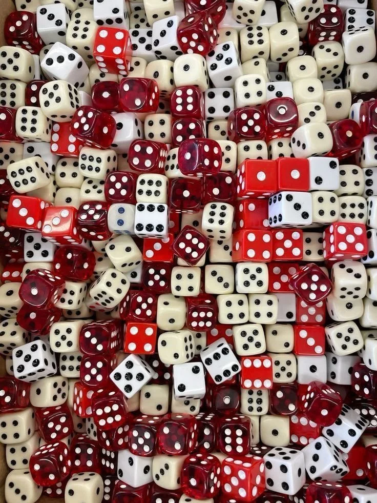 A large pile of red, white, and cream dice with black and white pips.