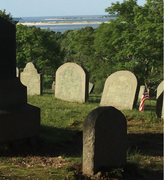 Headstones in a cemetery overlooking water
