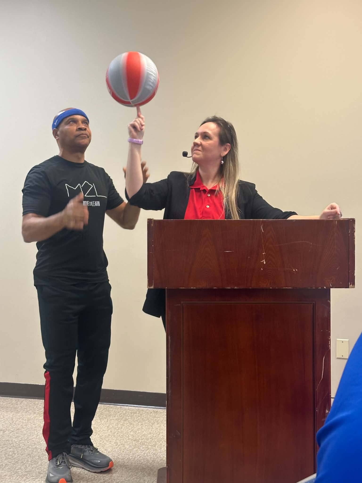Dr. Stapp spinning a basketball at a podium