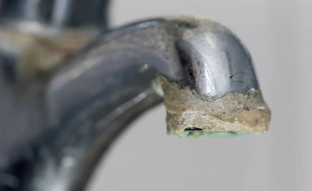 An image showcasing the effects of Hard Water build up on a drain.