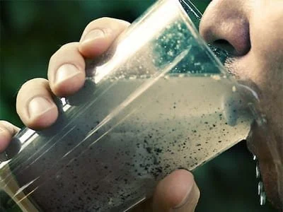 a guy drinking dirty water from a glass