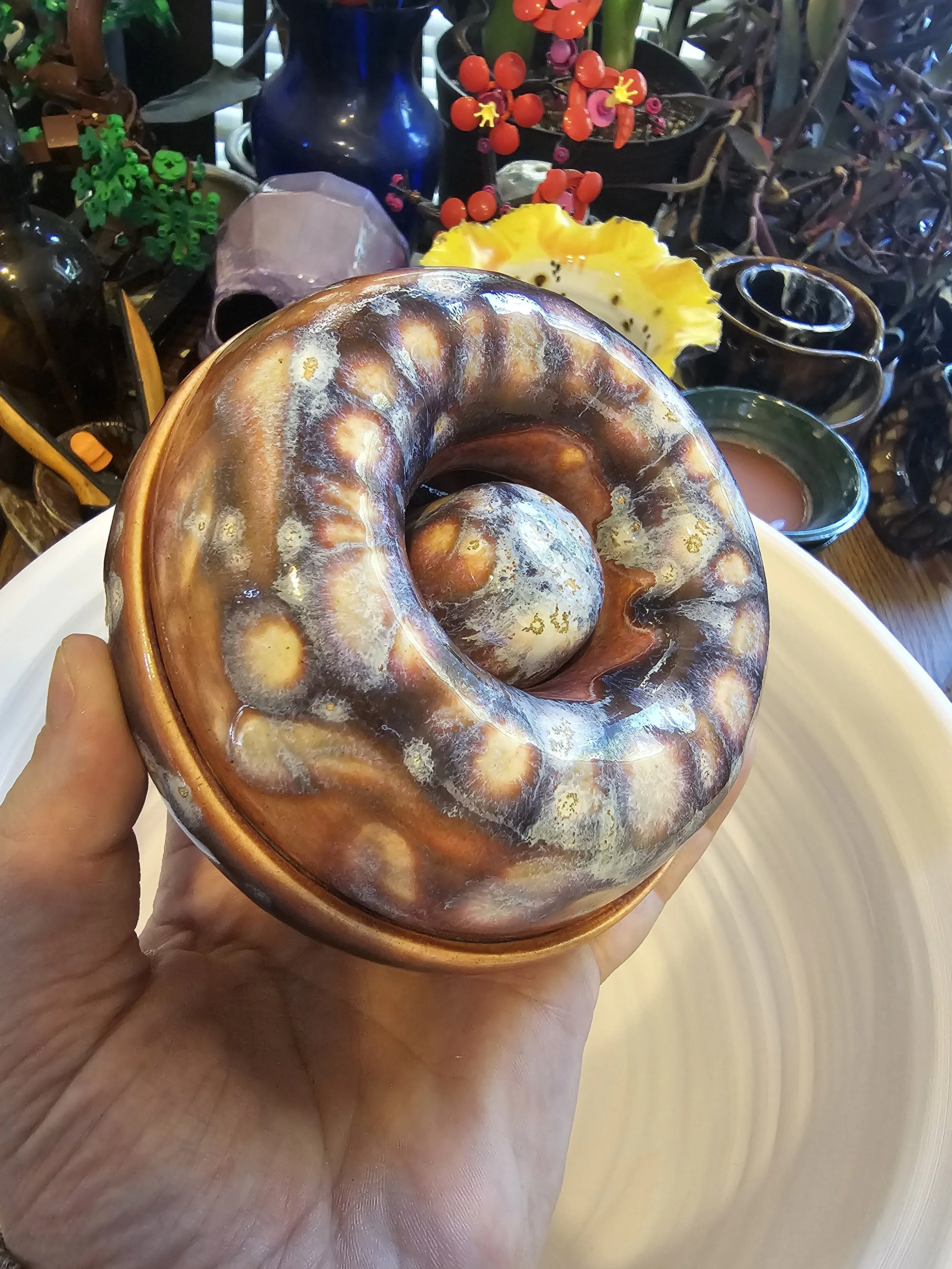 A hand holding a polished ashtray.