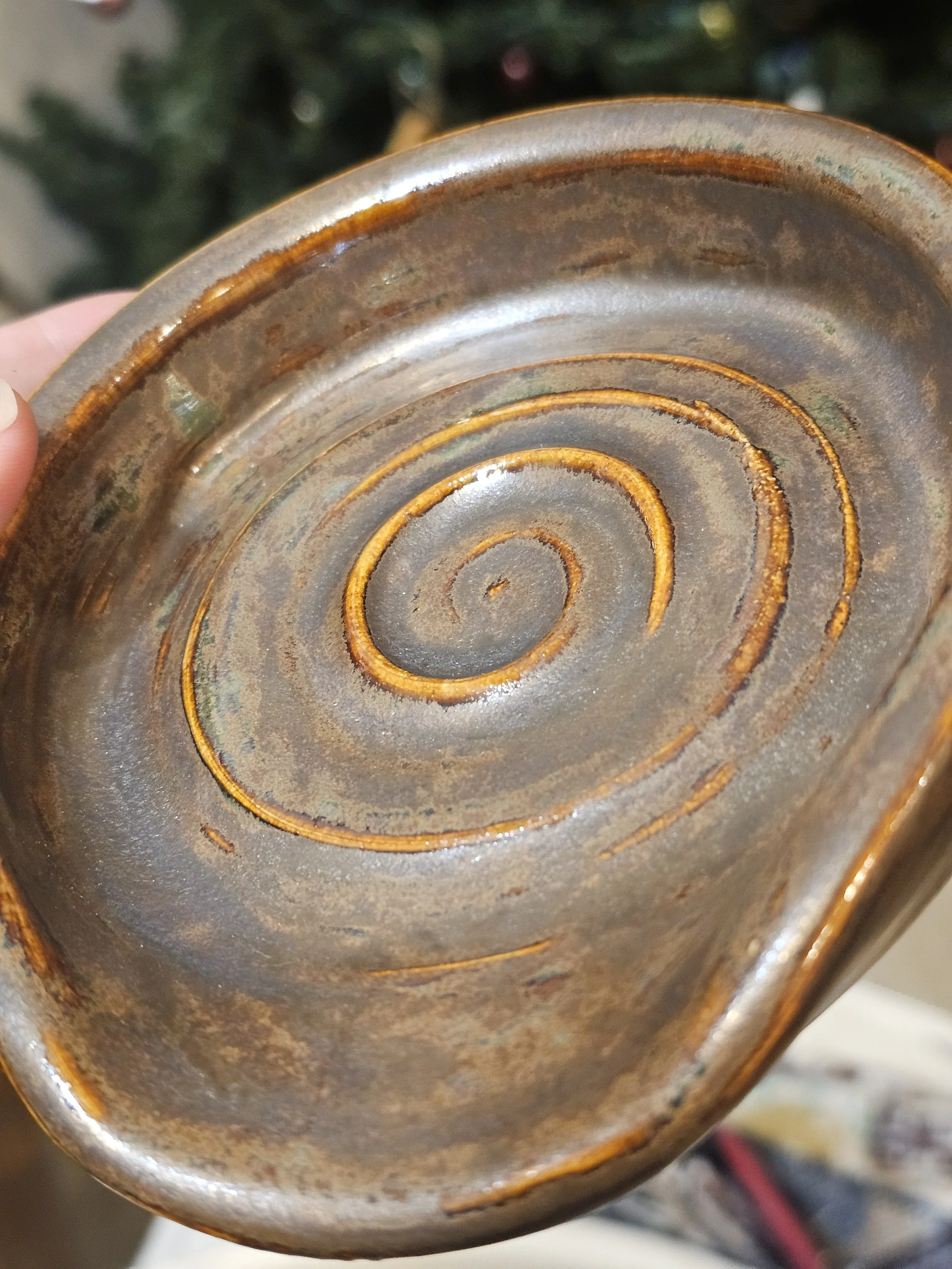 Close-up of the bottom of a rusty, circular metal object with concentric rings and a worn, weathered surface.