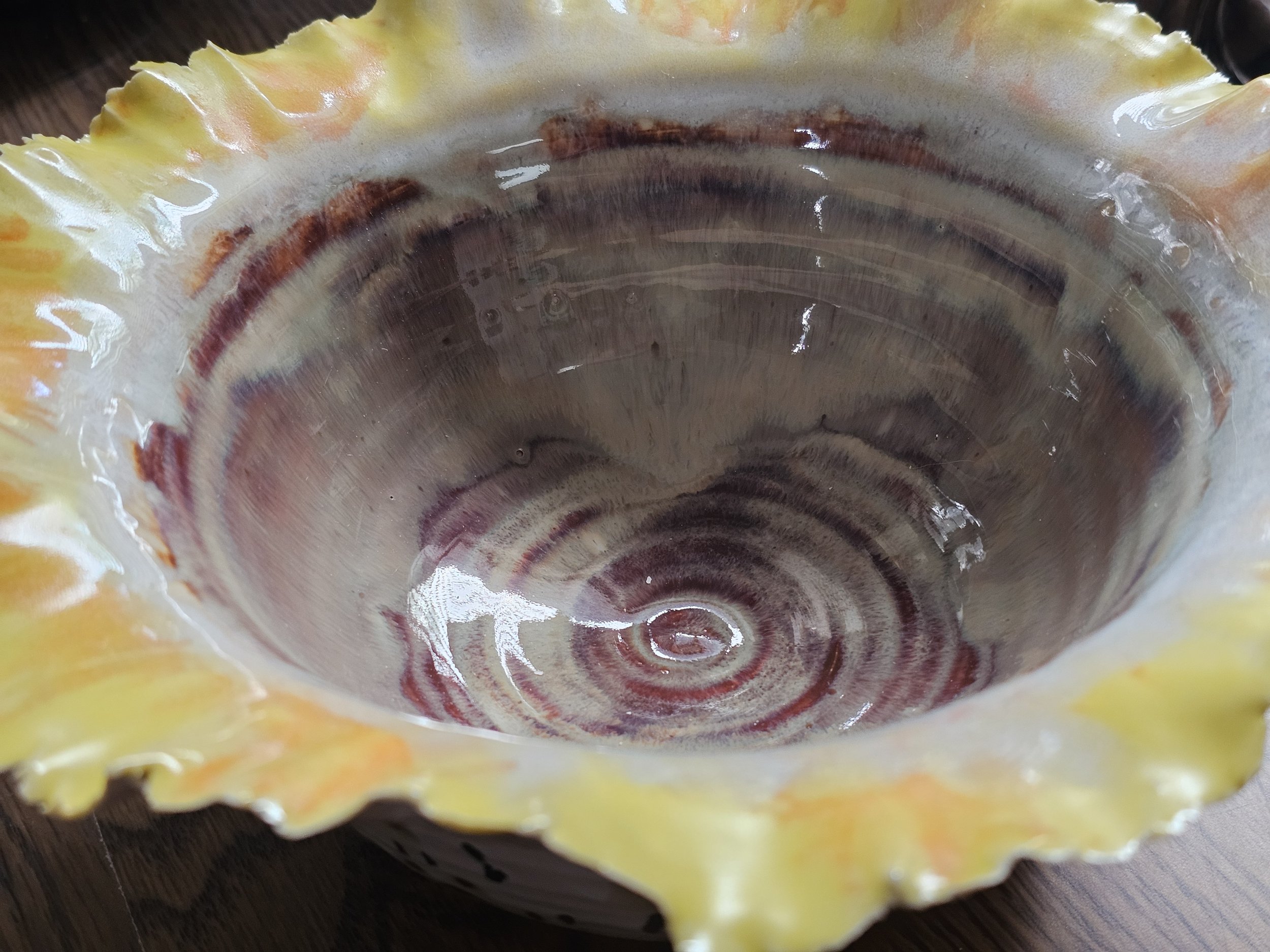 Close-up of the inside of a ceramic bowl , showing the concentric circular pattern and texture.