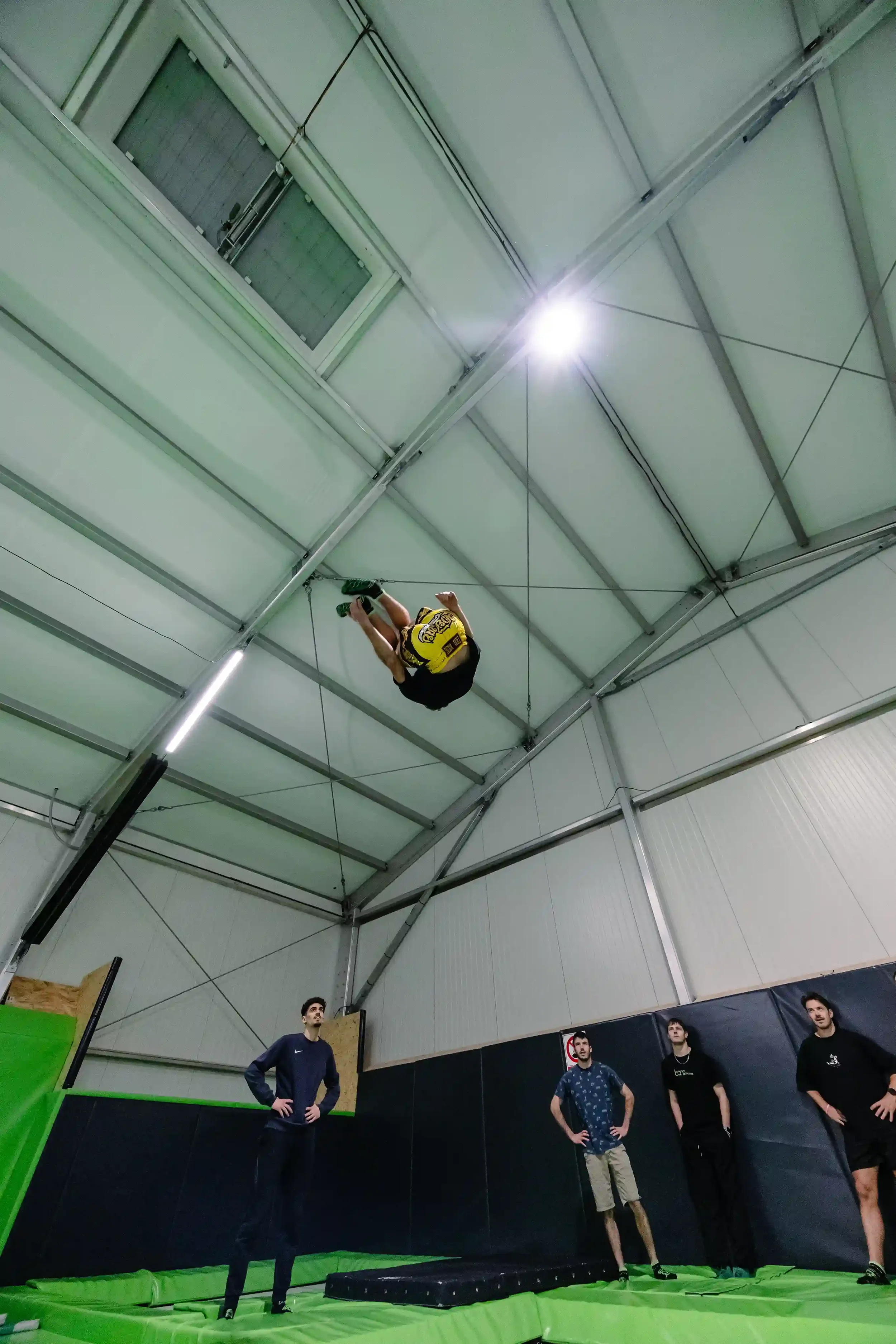 Jeune qui fait du trampoline à BAM FREESPORTS ANNECY entouré d'autres clients