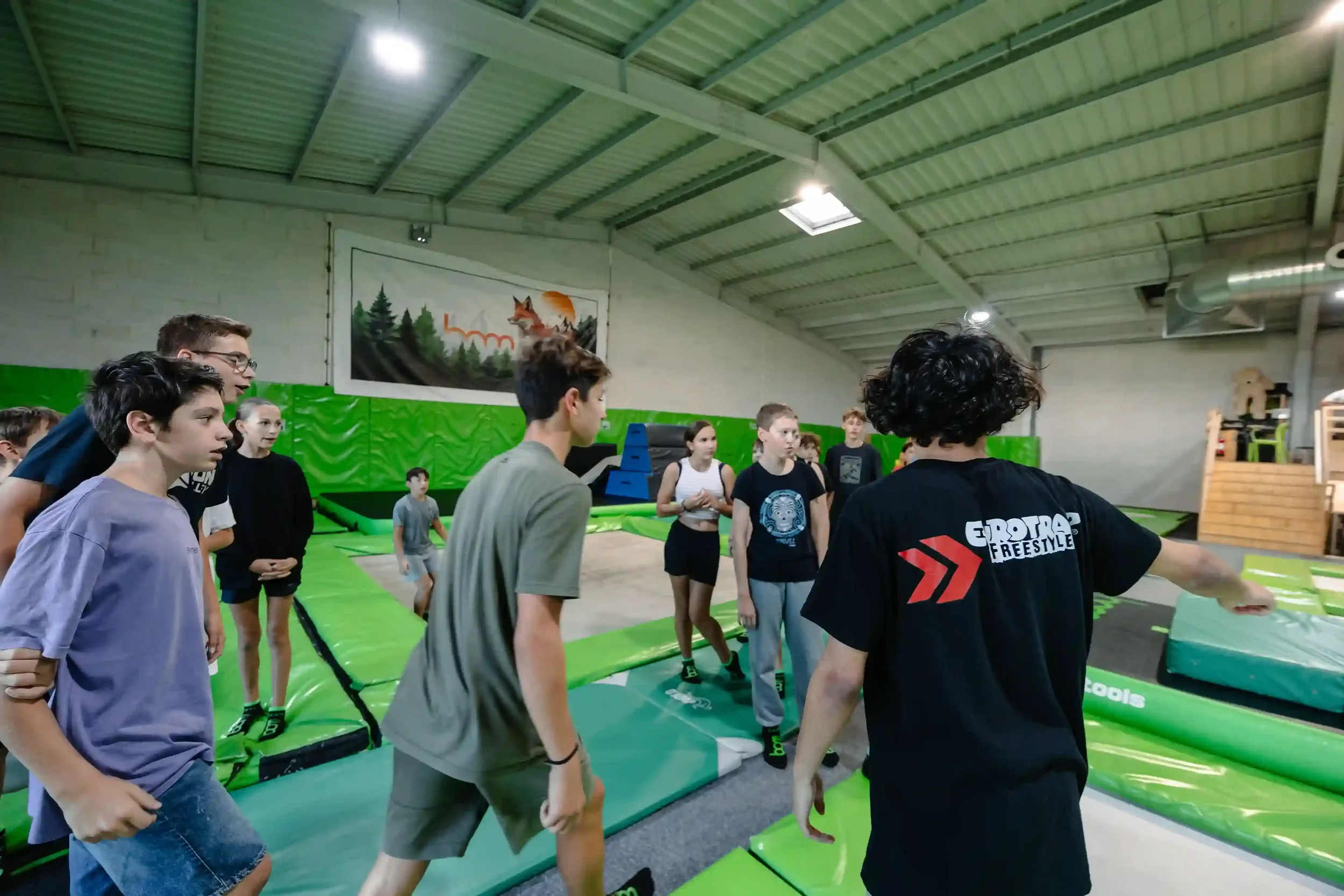 Coach qui accompagne les adolescents sur les toiles dans la salle de trampoline BAM FREESPORTS Cambéry