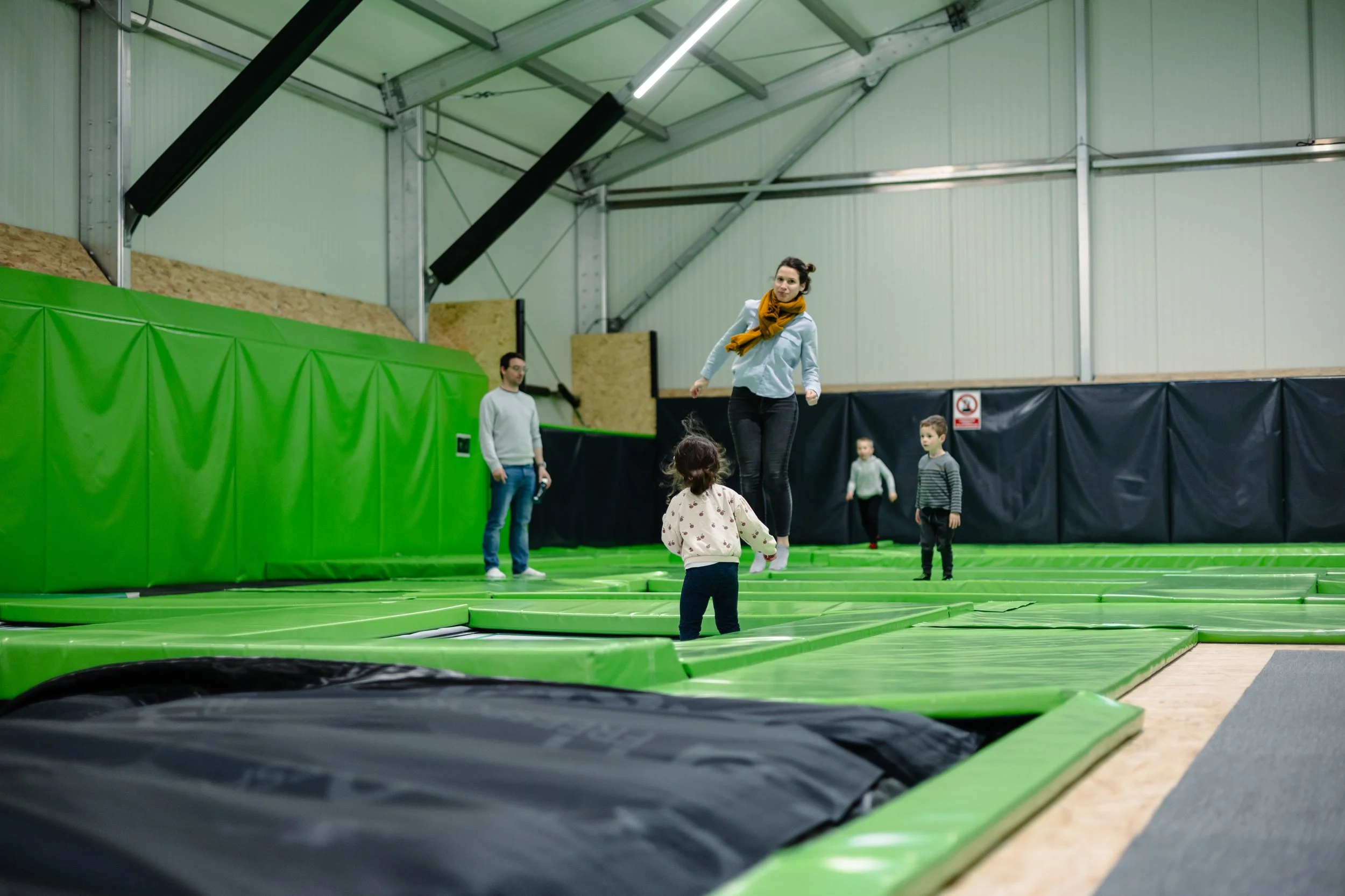 Petit enfant qui saute sur un trampoline avec sa maman dans la salle de trampoline de BAM FREESPORTS