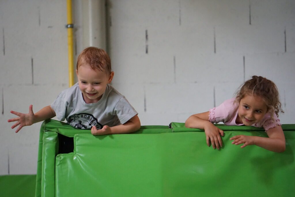 Petits enfants qui jouent en haut d'un module de trampoline dans la salle de BAM FREESPORTS