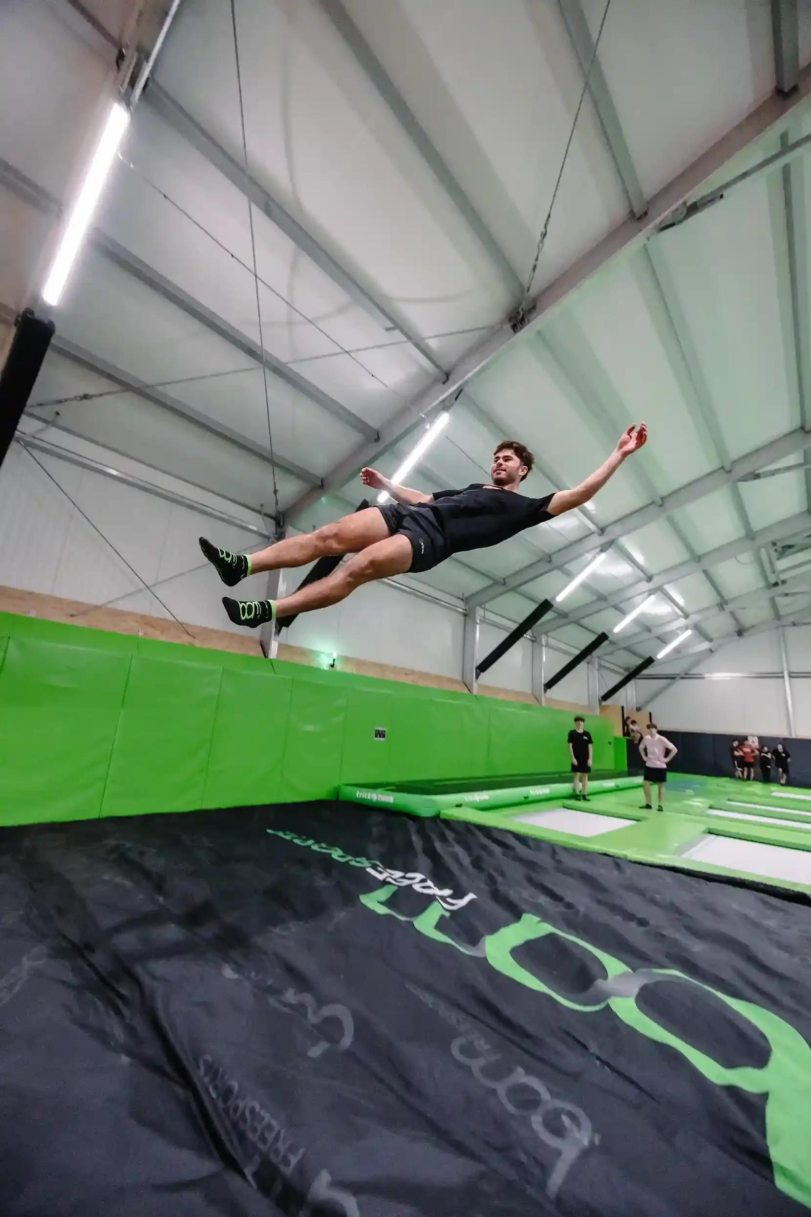 Jeune qui saute depuis la mezzanine pour atterrir dans l'airbag de la salle de trampoline de BAM FREESPORTS Annecy.